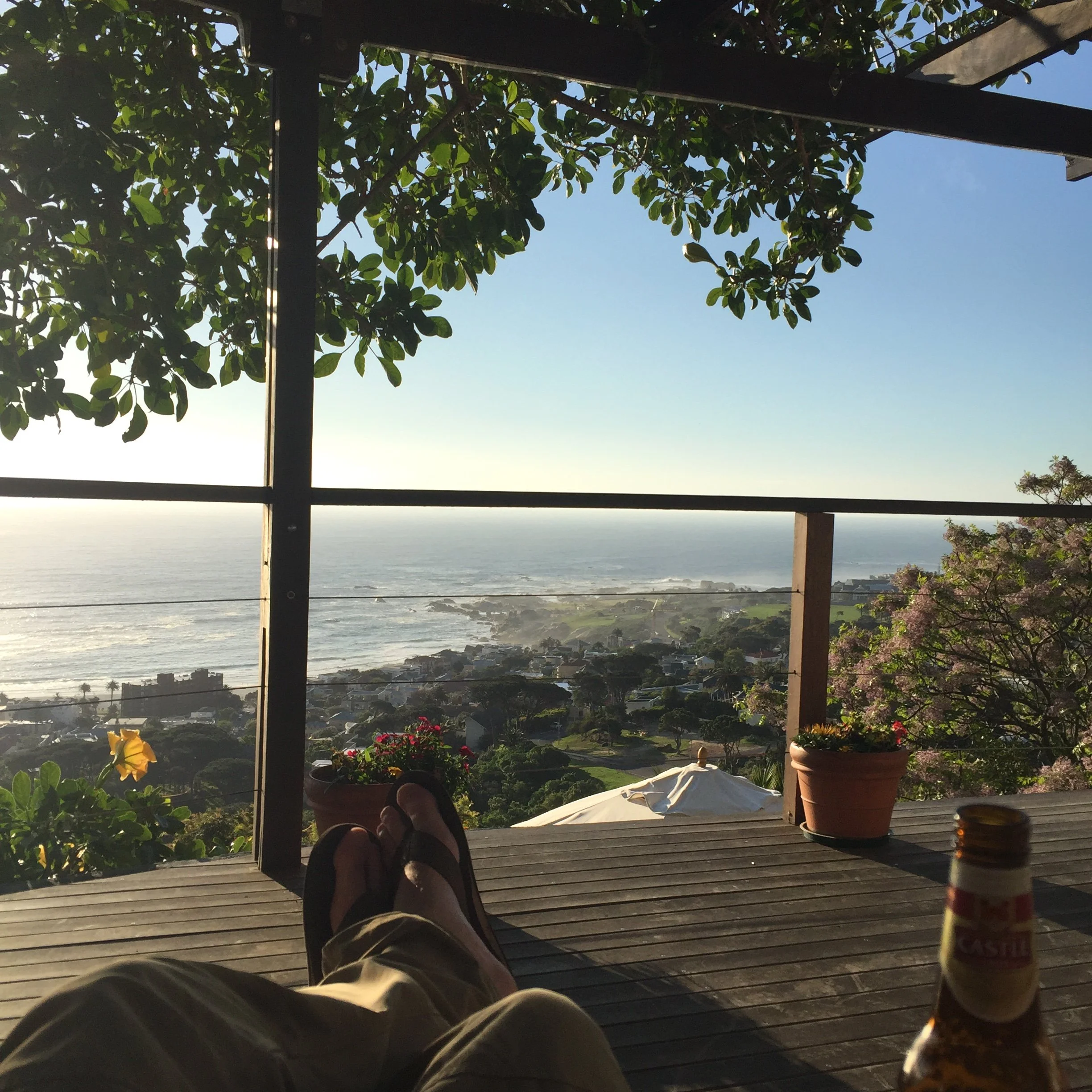 View from the Boutique @10 balcony over Camps Bay, with the ocean and coastline beyond the deck.