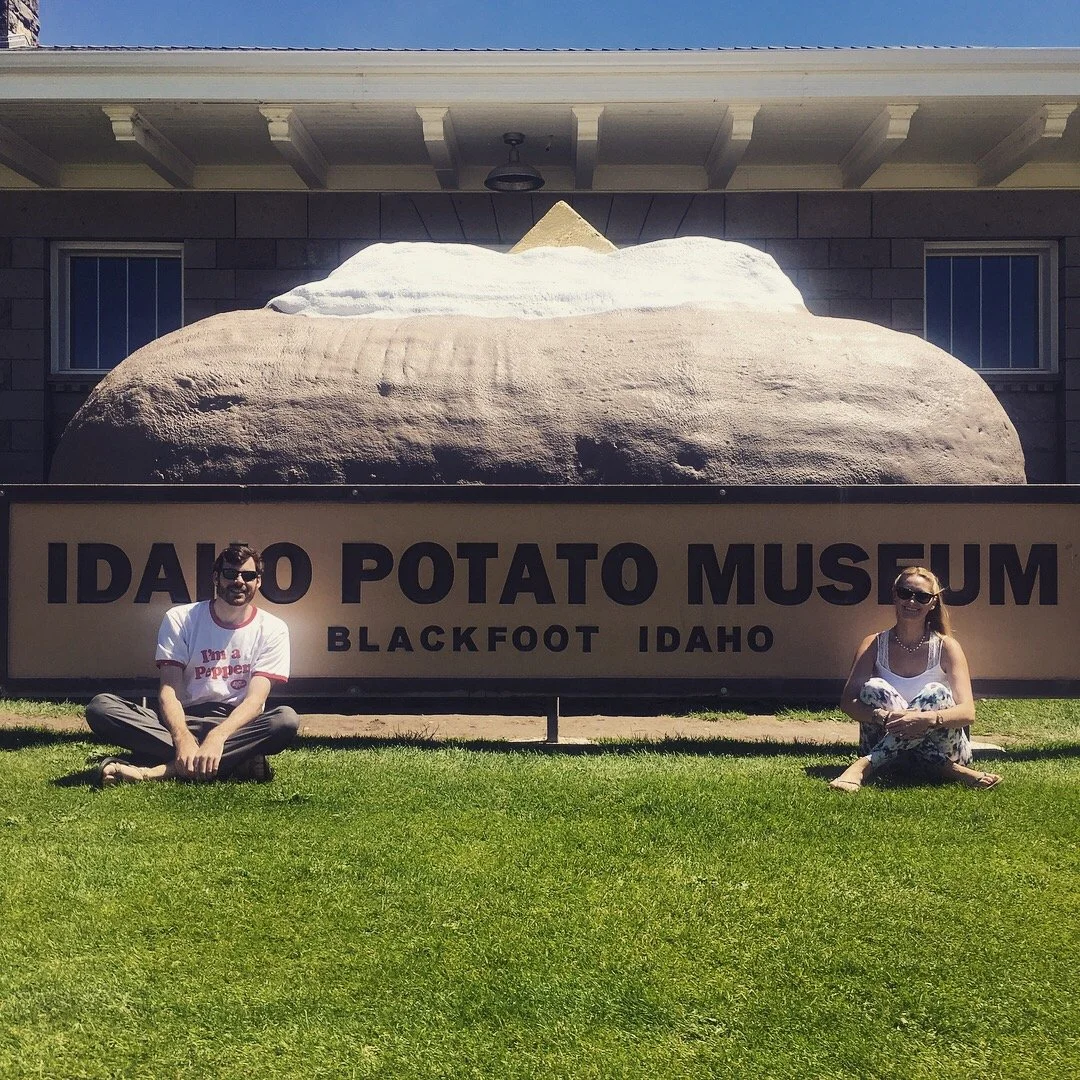 Two people sitting beneath the giant potato sculpture at the Idaho Potato Museum in Blackfoot, Idaho.