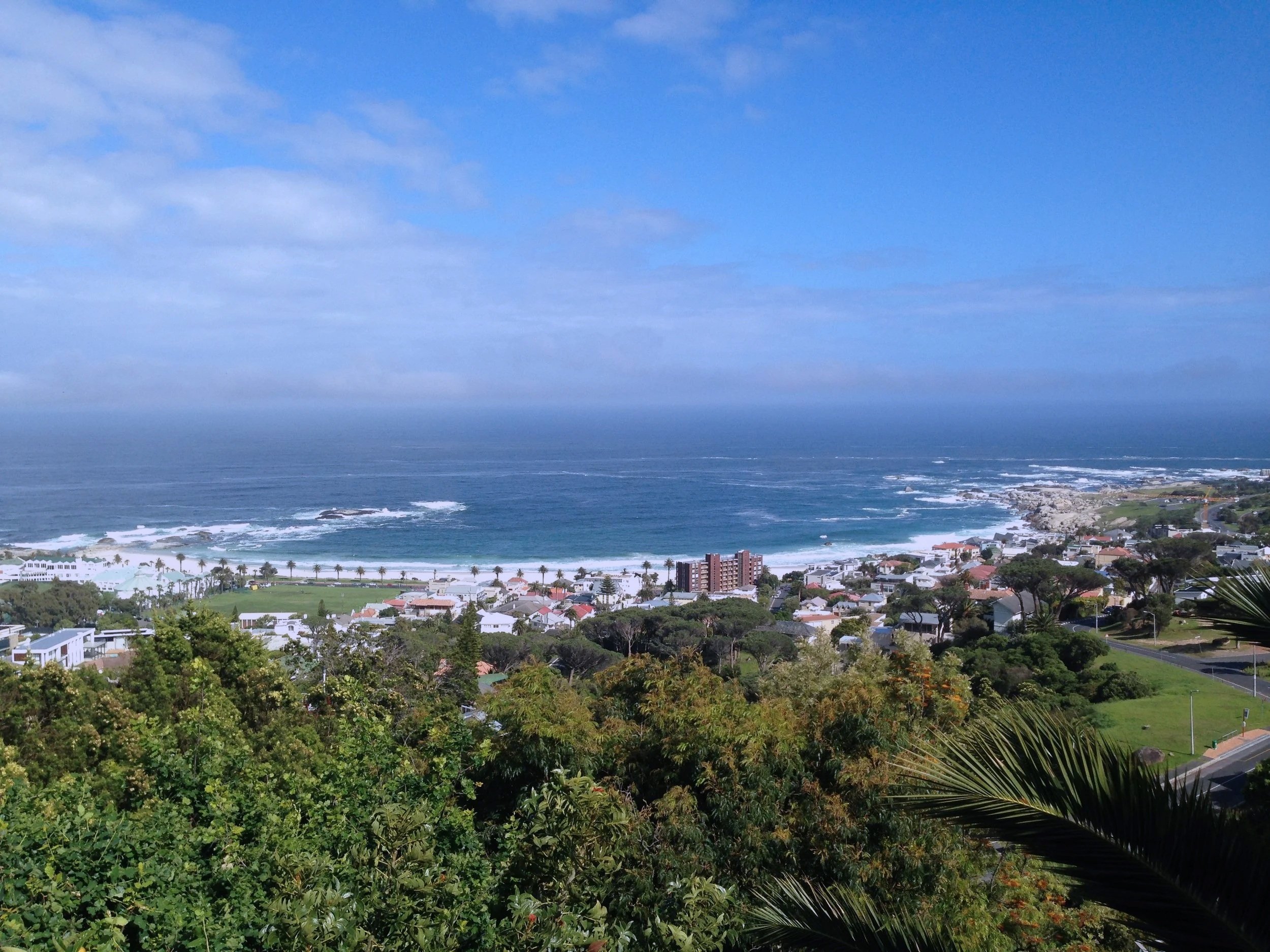 View over Camps Bay’s beach, neighborhood, and coastline in South Africa.