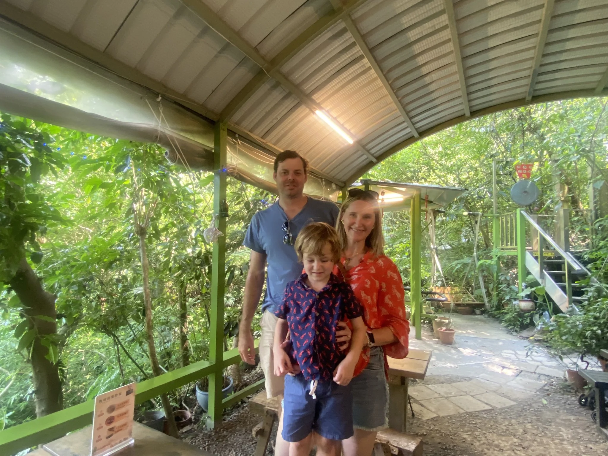 Four people at an open-air tea house surrounded by greenery in Jiufen.