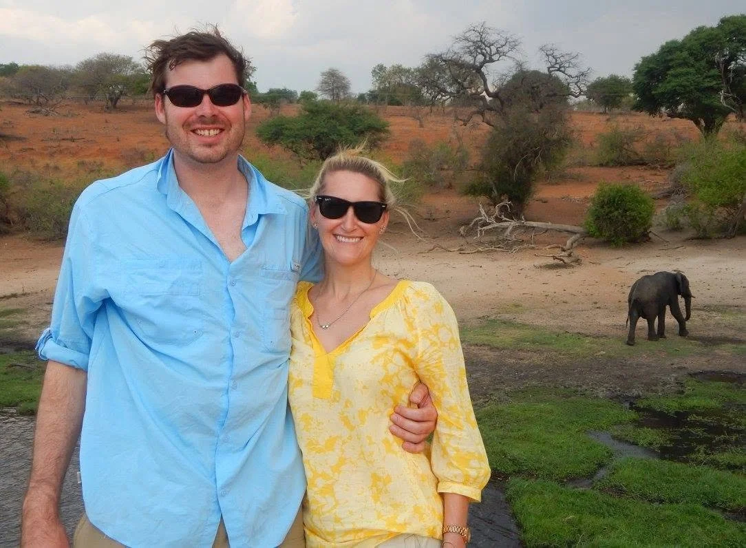 Couple on safari in Botswana with an elephant in the background.