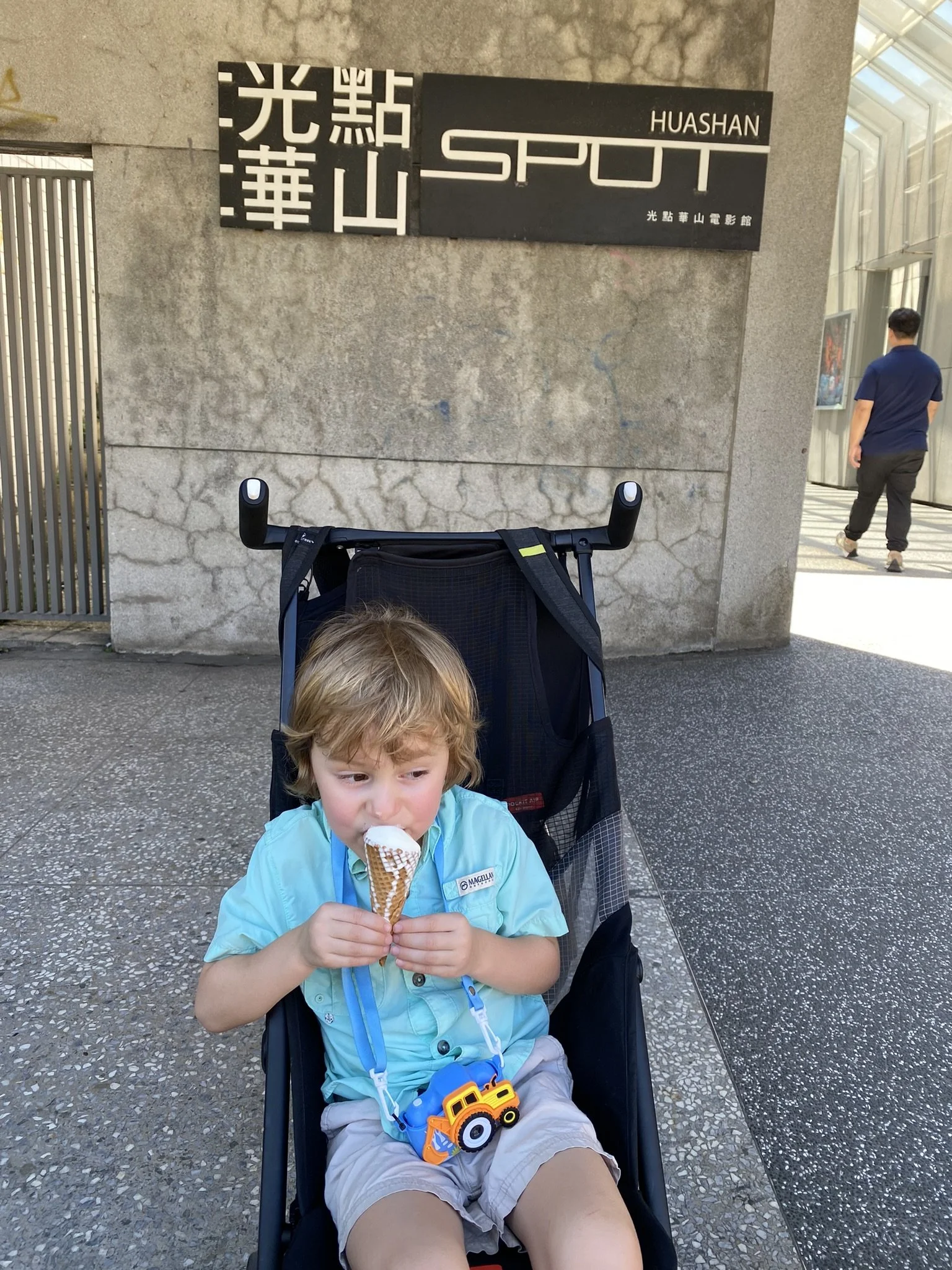 A child eating an ice cream cone in a stroller at Huashan 1914 Creative Park.