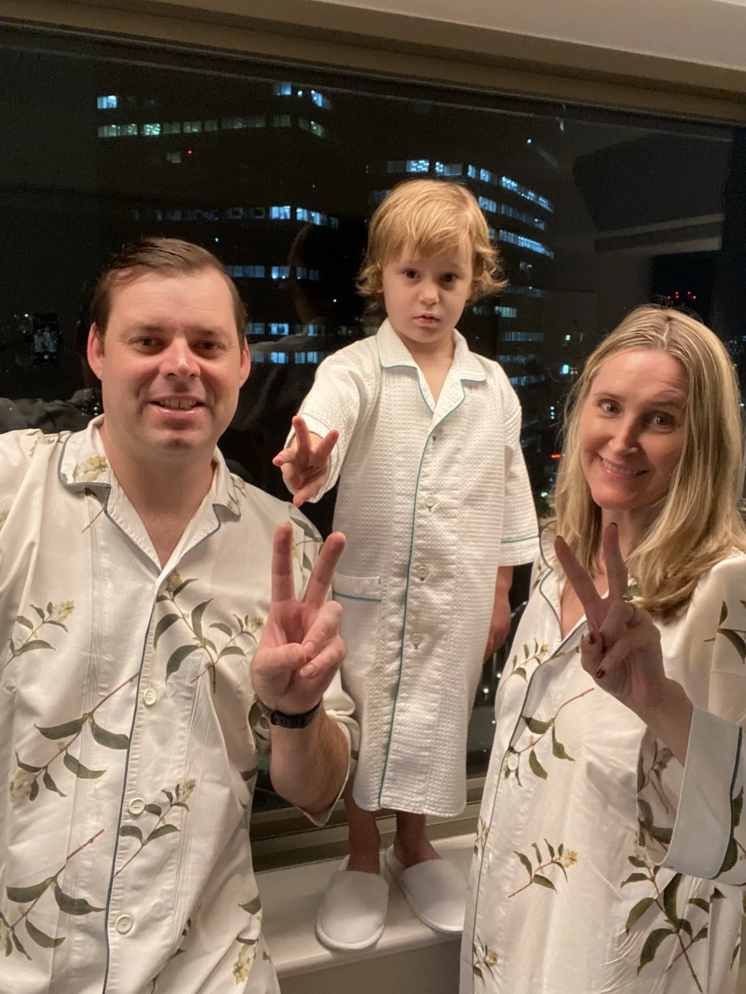 Family of three posing in matching pajamas at their hotel in Tokyo.