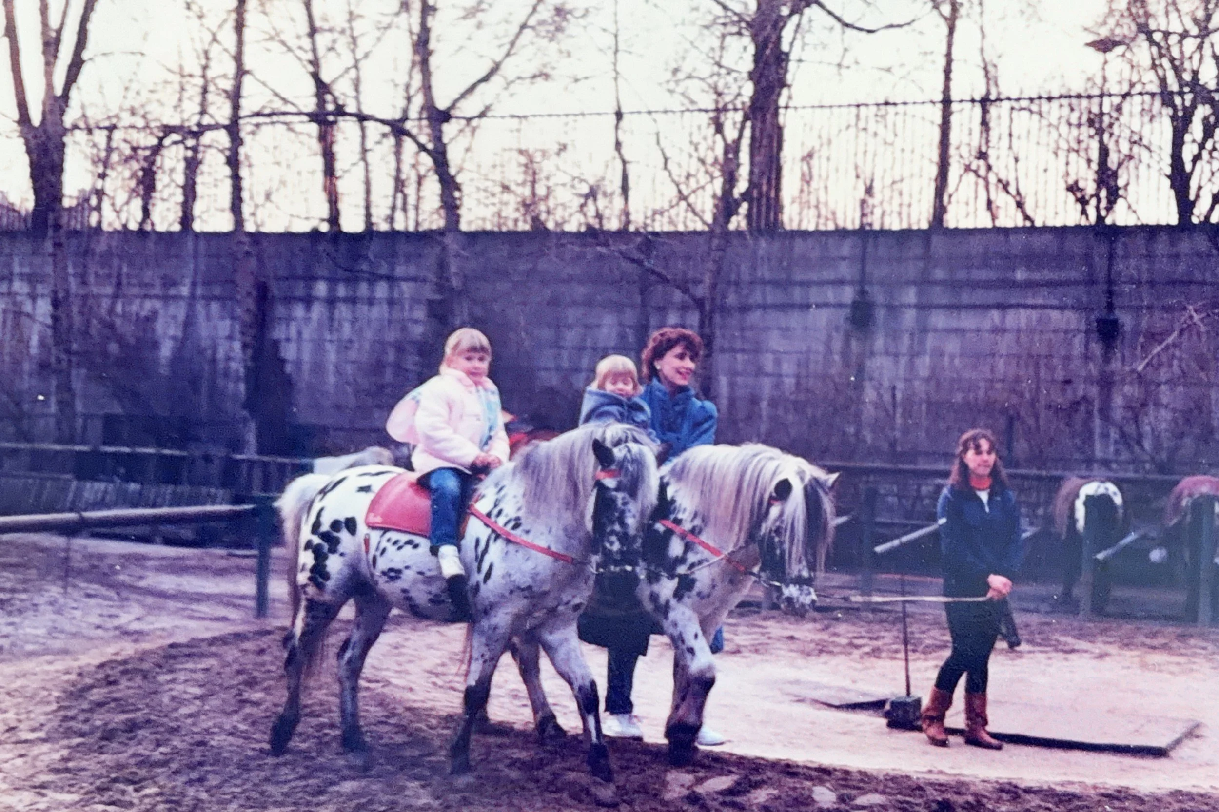 Young girl riding a pony at the Berlin Zoo in West Berlin, with other children riding nearby.