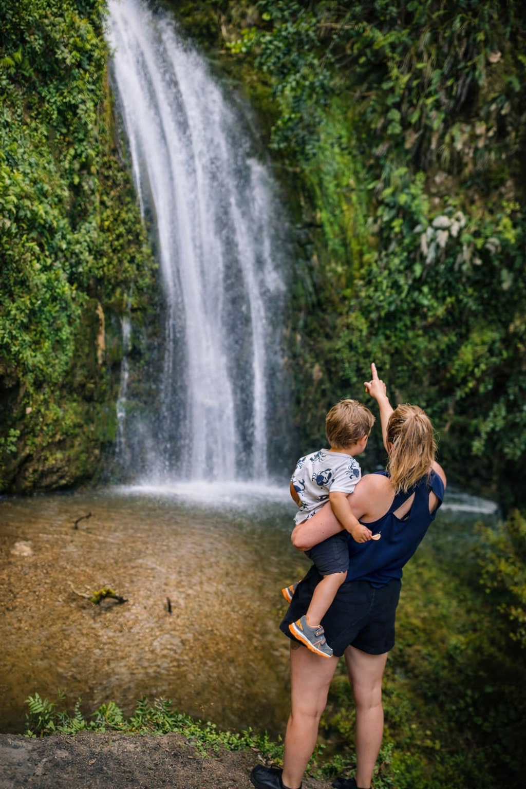 Hayley and son admiring a waterfall in Hawke's Bay, New Zealand, reflecting the local roots behind Innerbloom Studio's web design and branding work