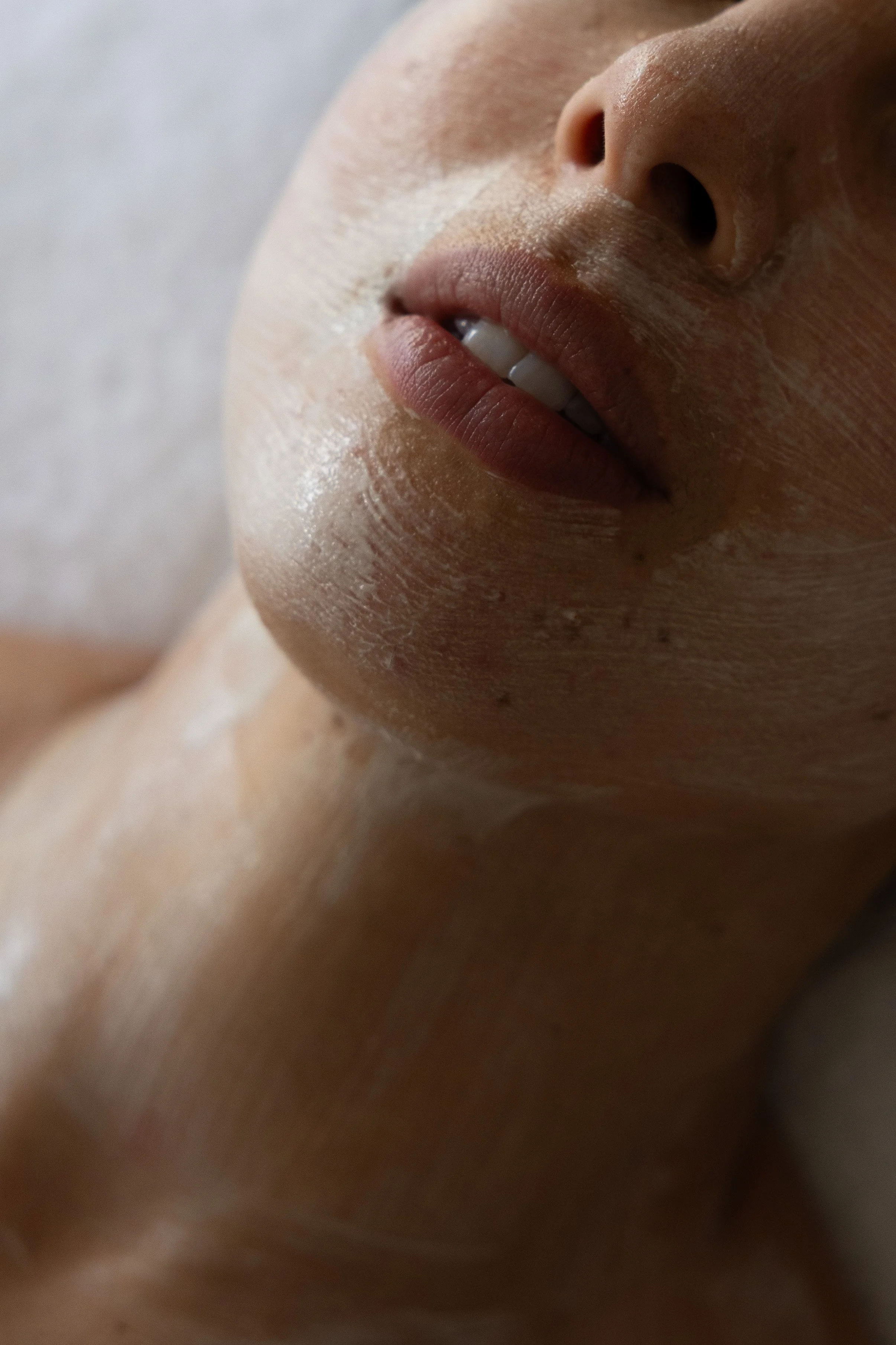 Close-up of a person's face, focusing on the lips and nose, with a slight smile showing teeth.