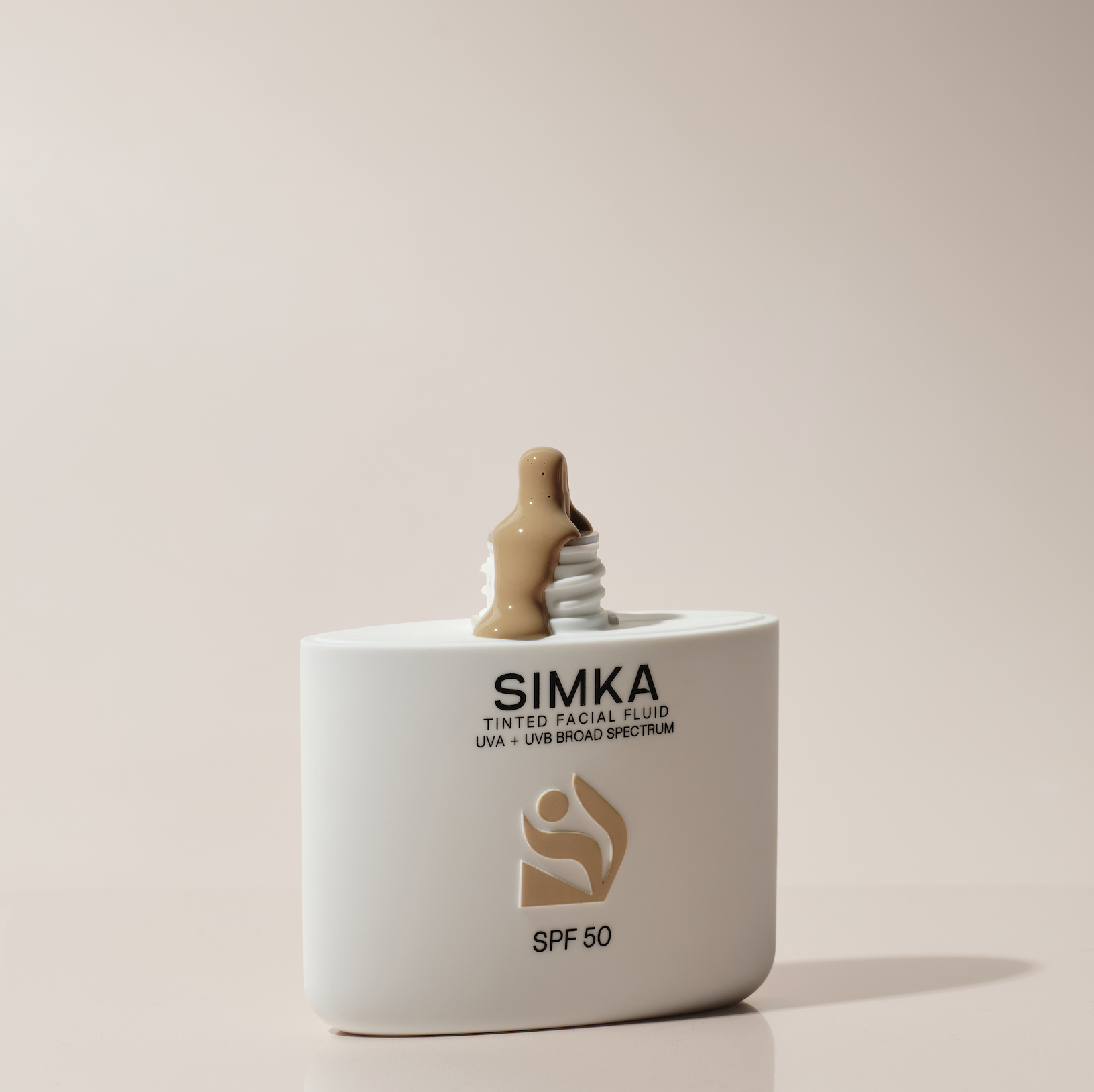 A white bottle of SIMKA tinted facial fluid with SPF 50, displaying a swirl of beige facial product dripping down from the top of the bottle, against a plain off-white background.