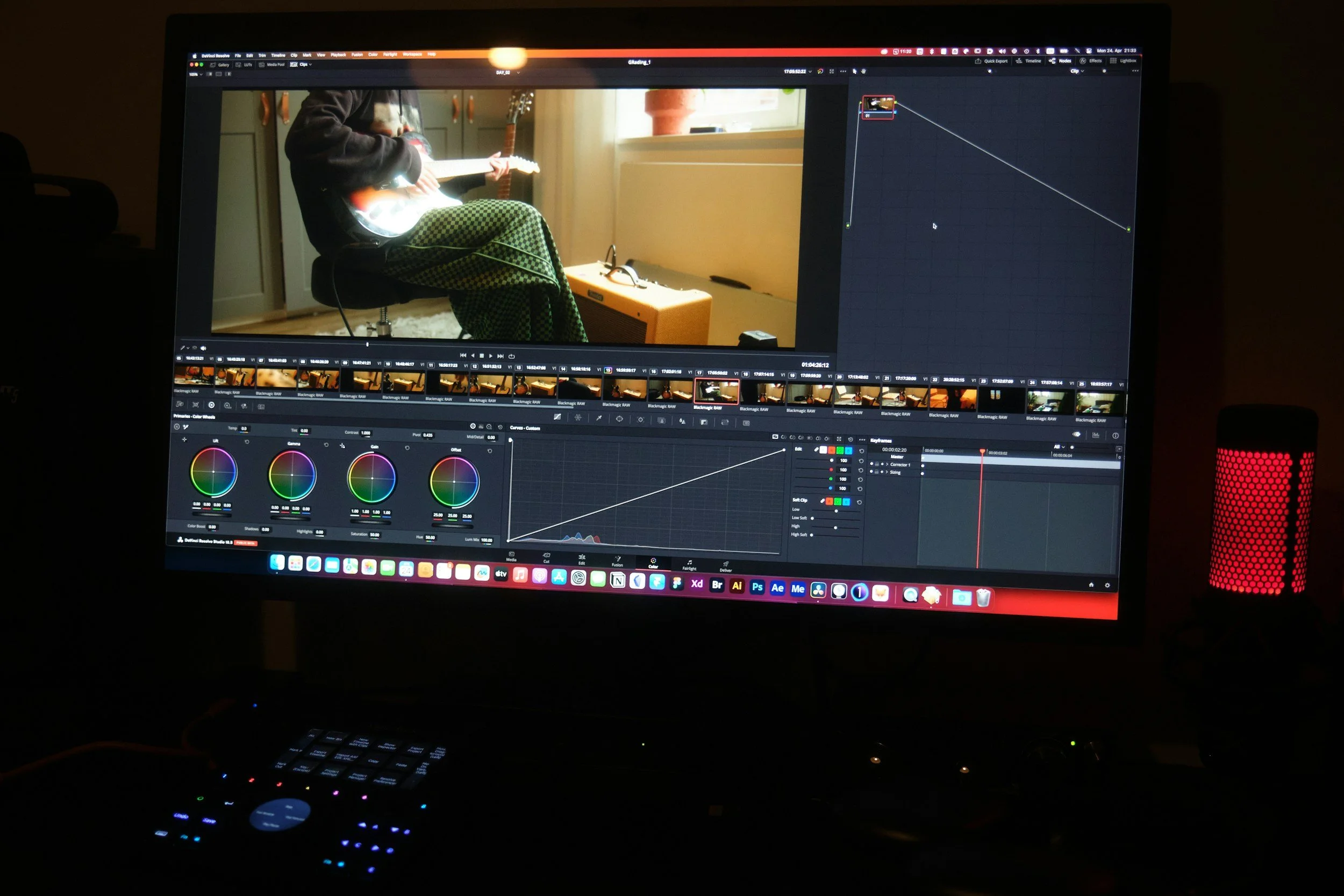 Computer screen displaying video editing software with a photo of a person playing an electric guitar in a room, with video clips and color correction tools visible.