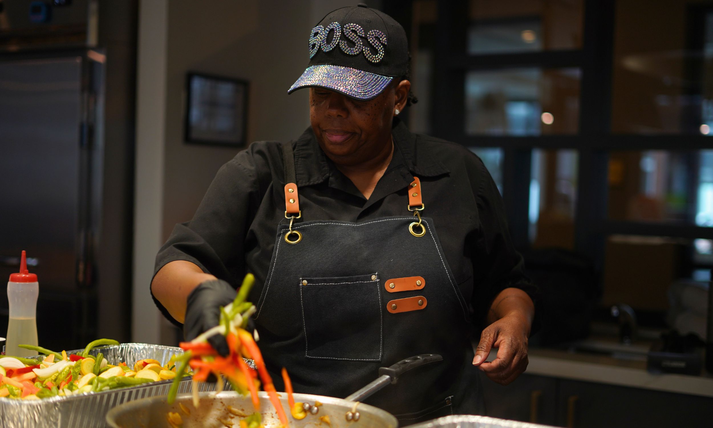 Female private chef sauteing vegetables for a dinner party