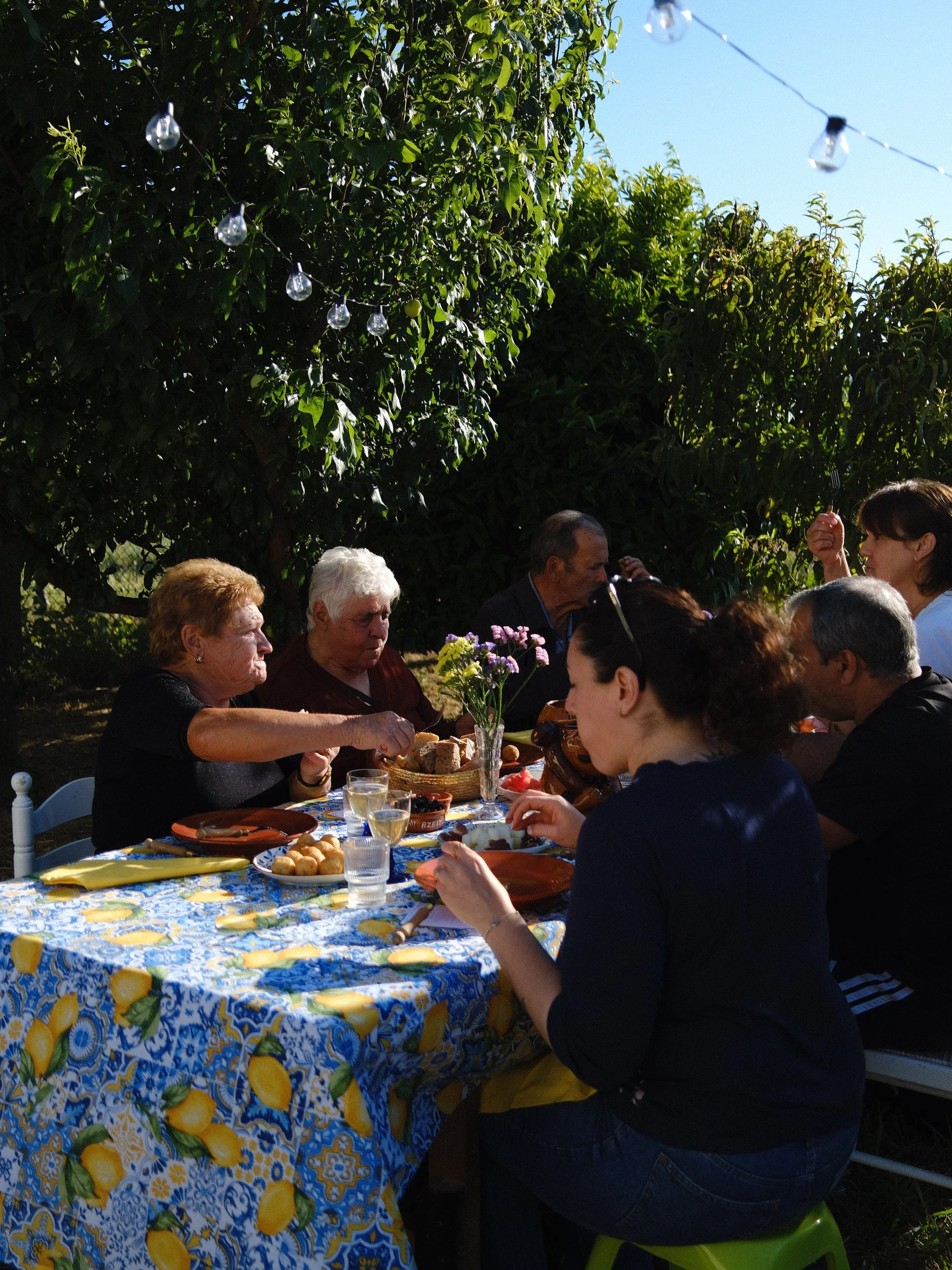 Guests gathered around a shared table enjoying food, wine and conversation at Mediterranean Grandma Supper Club