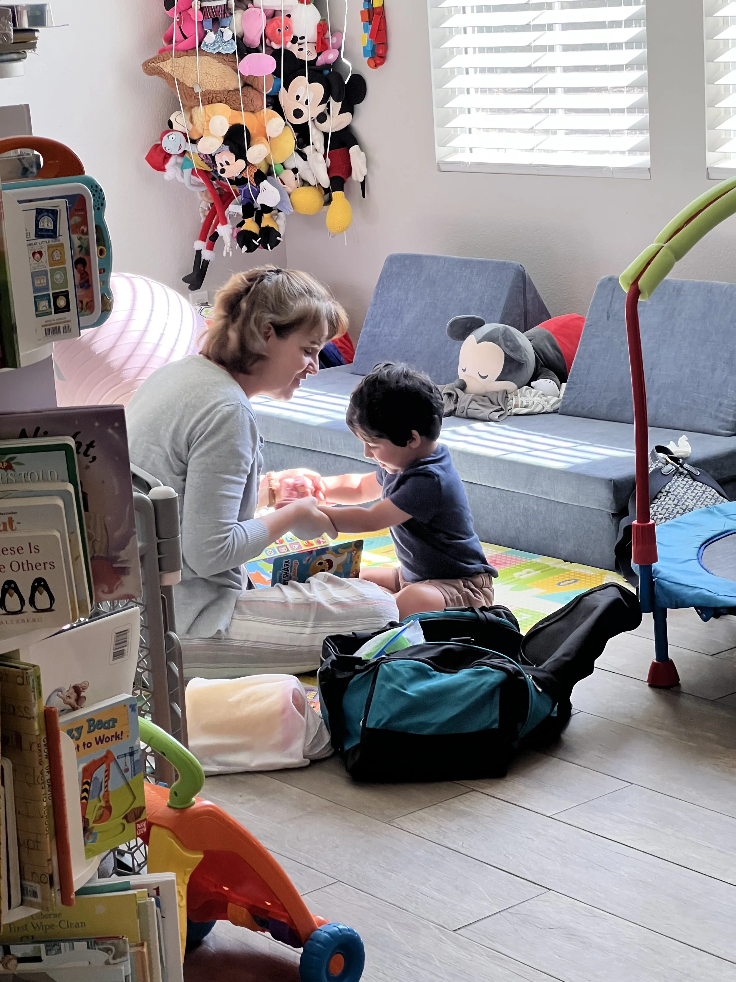Nathalie Seguin, OTR/L, SWC, CBS working with a young child and reading a book