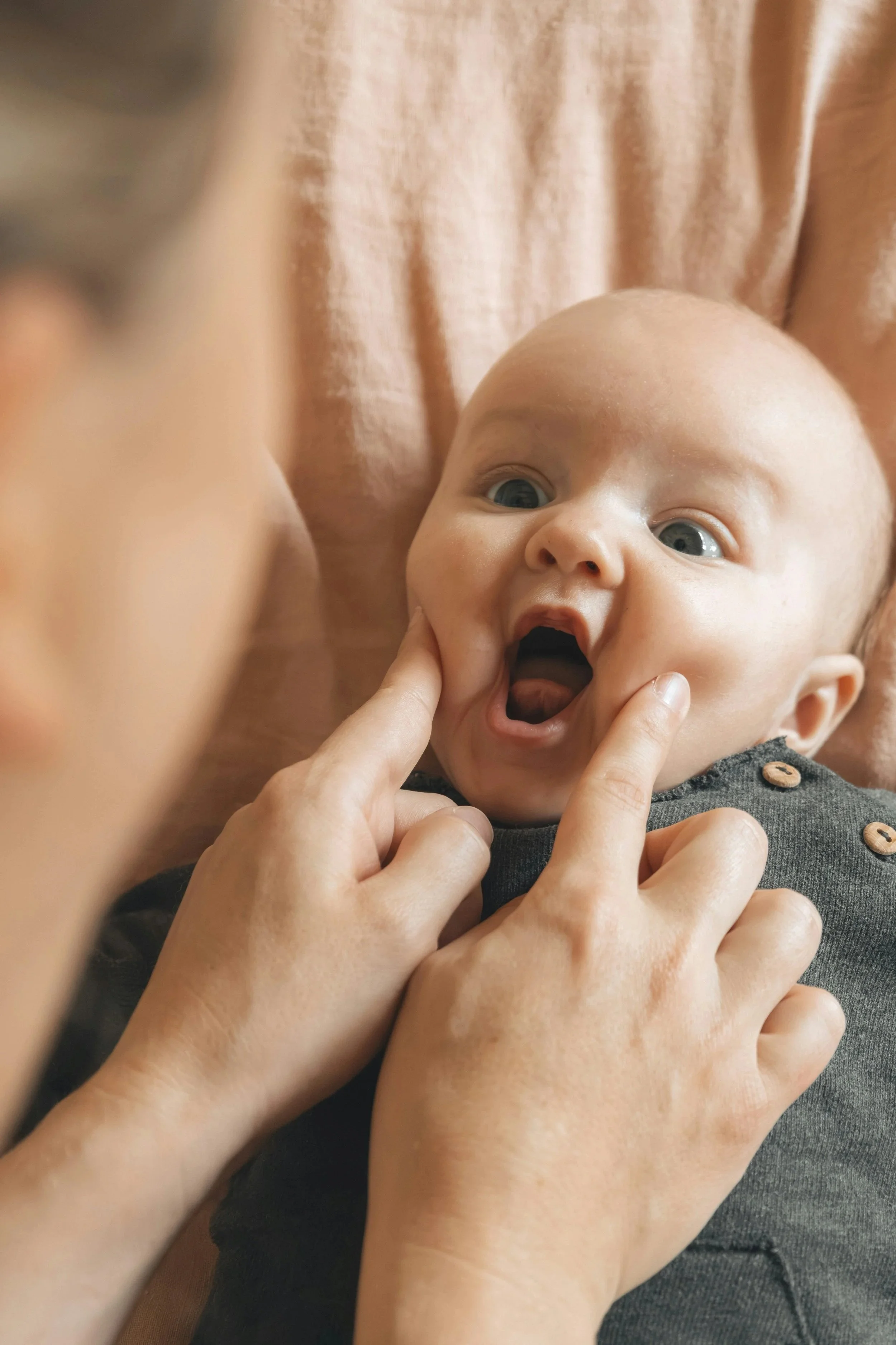 An infant receiving some oral/facial massage during an occupational therapy session to improve his oral motor skills in preparation for breastfeeding/bottle feeding.