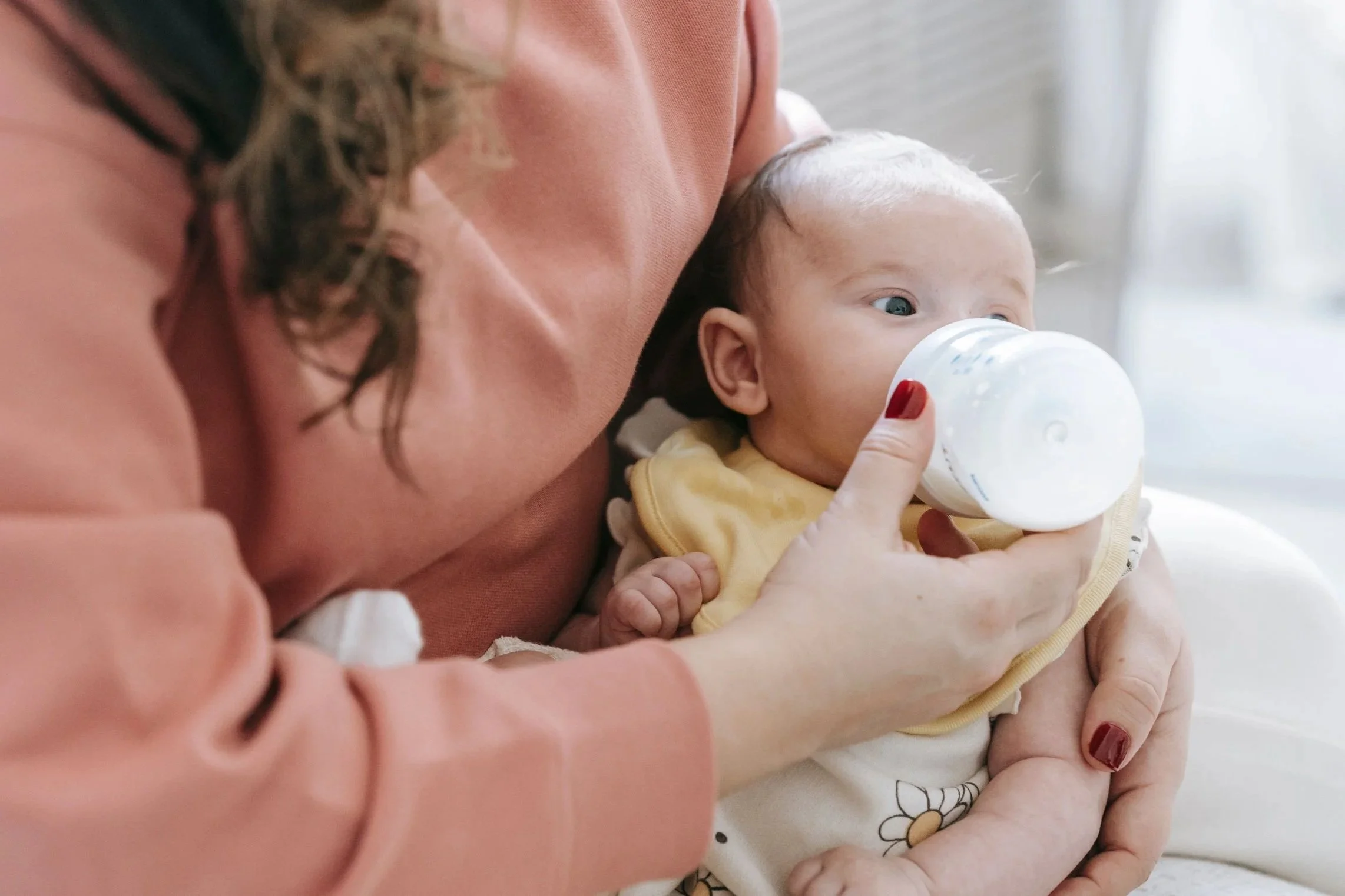A mother bottle feeding her baby during an occupational therapy/feeding evaluation.