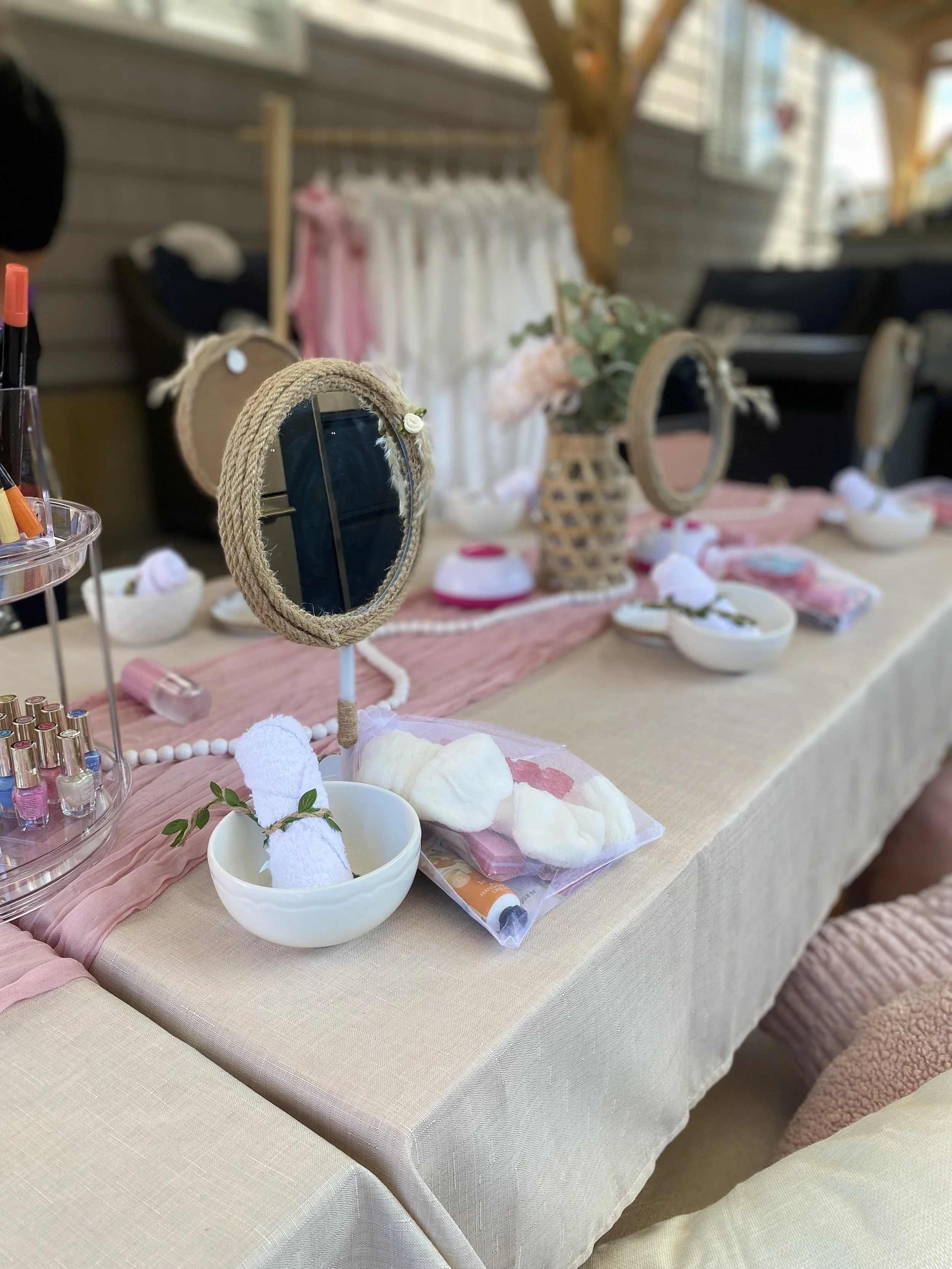 Display of spa or beauty products on a table with decorative elements including towels, small bowls, and mirrors.