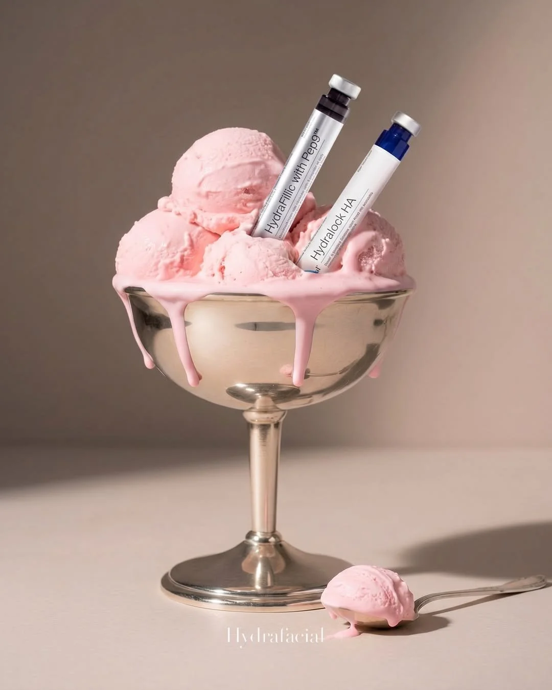 Eiswaffel mit rosa Eiskugel im Metallglas, das rosa geschmolzen ist, mit zwei medizinischen Spritzen und einem Löffel mit kleiner rosa Eiskugel.