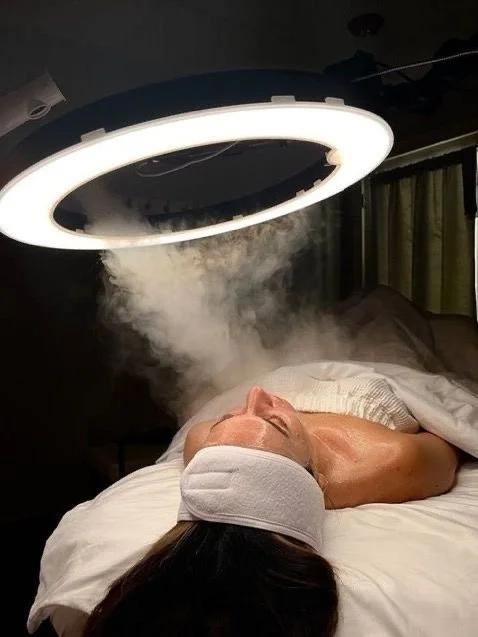 Eine Person liegt auf einem Bett unter einer warmen Lampe, die Dampf oder Nebel abgibt.