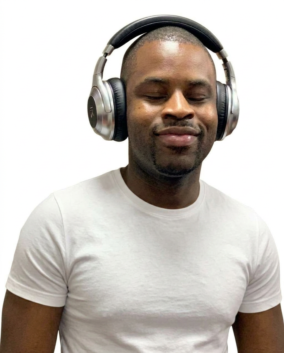 A man with closed eyes wearing headphones and a white t-shirt, smiling softly.