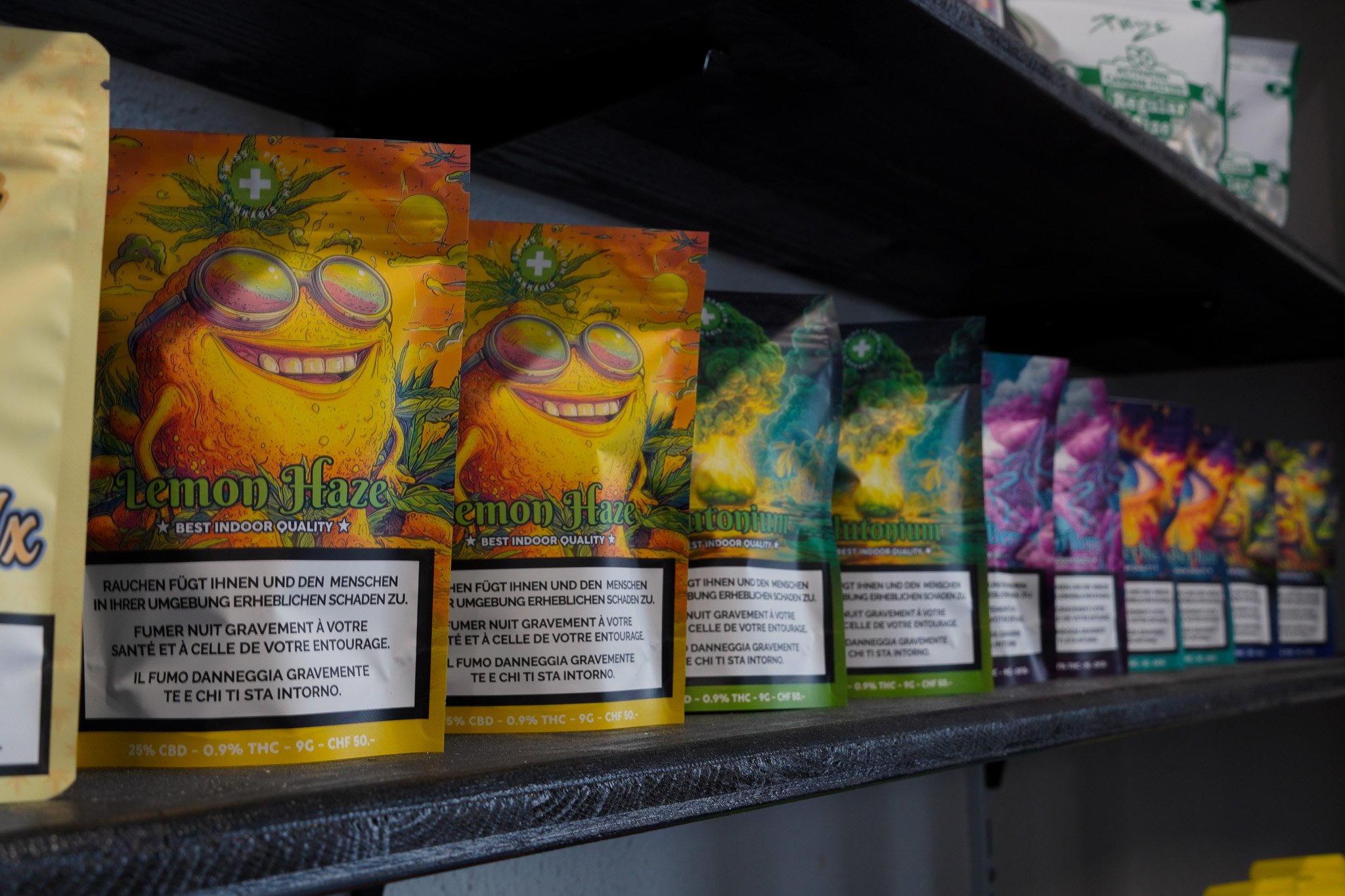 Colorful cannabis seed packets labeled "Lemon Haze" arranged on a store shelf.