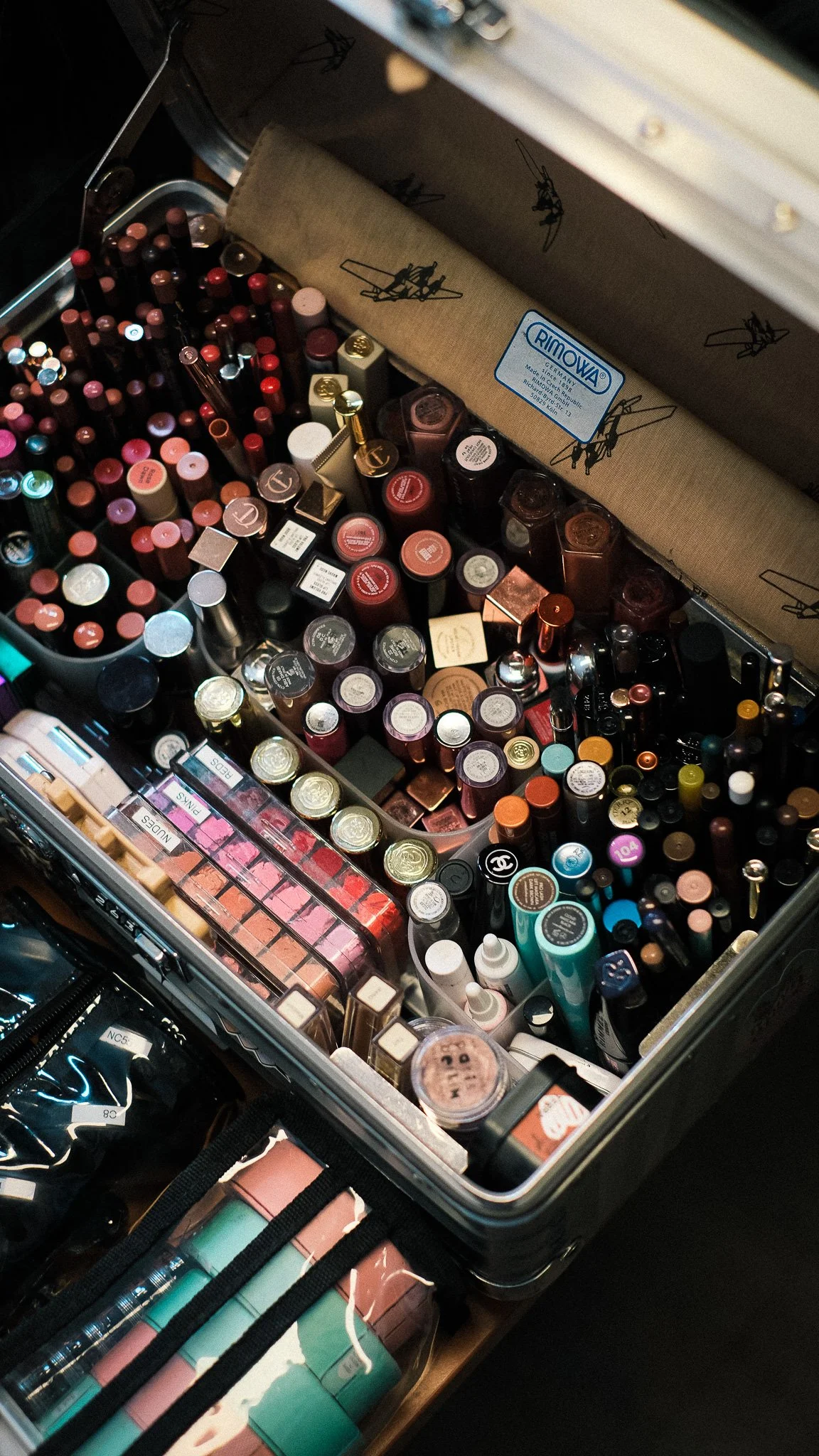 A collection of makeup products including lipsticks, lip glosses, and lip balms in a makeup case.
