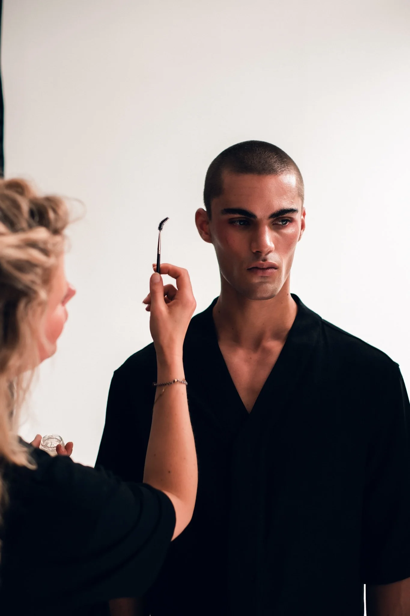 Makeup artist applying makeup to a model's face.