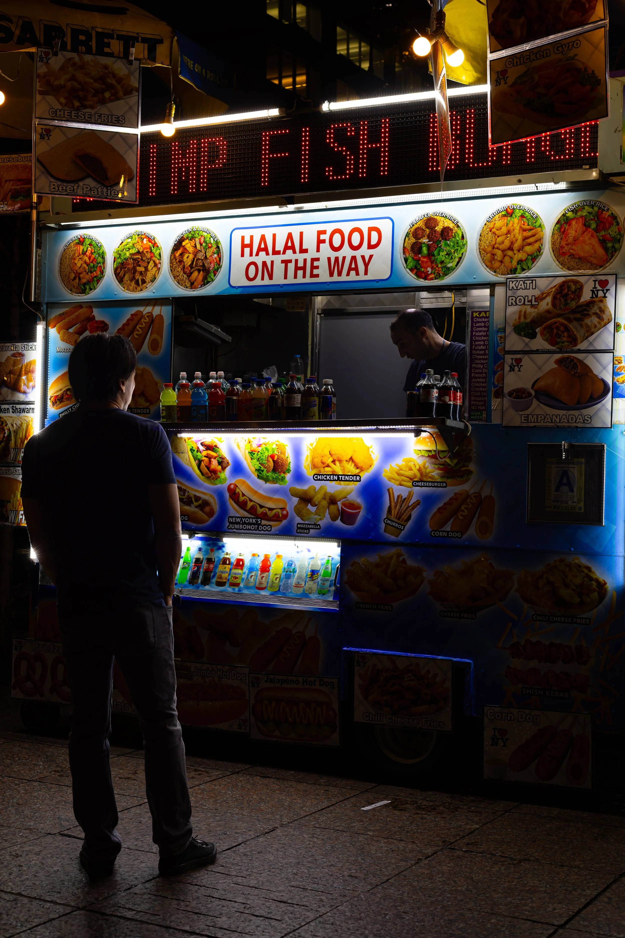 A shot of a guy ordering food from one of the many food carts around NYC.