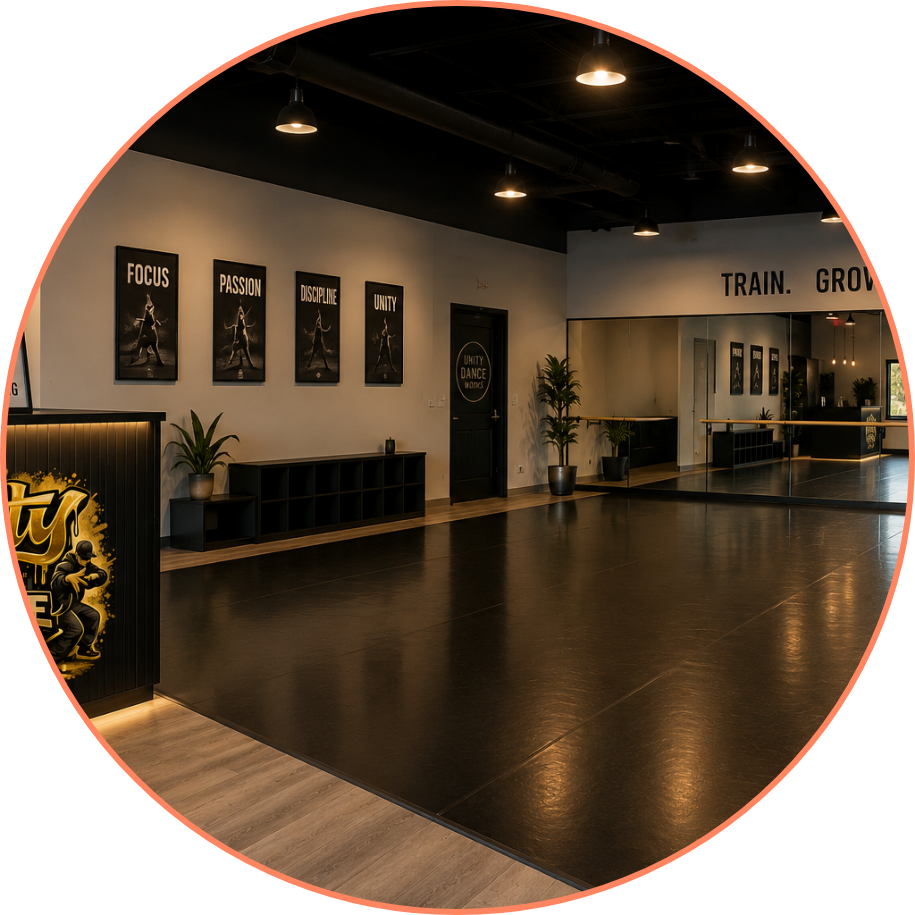 Dance studio with wall posters reading "Focus," "Passion," "Discipline," and "Unity," large mirror, ballet barre, plants, and a reception counter.