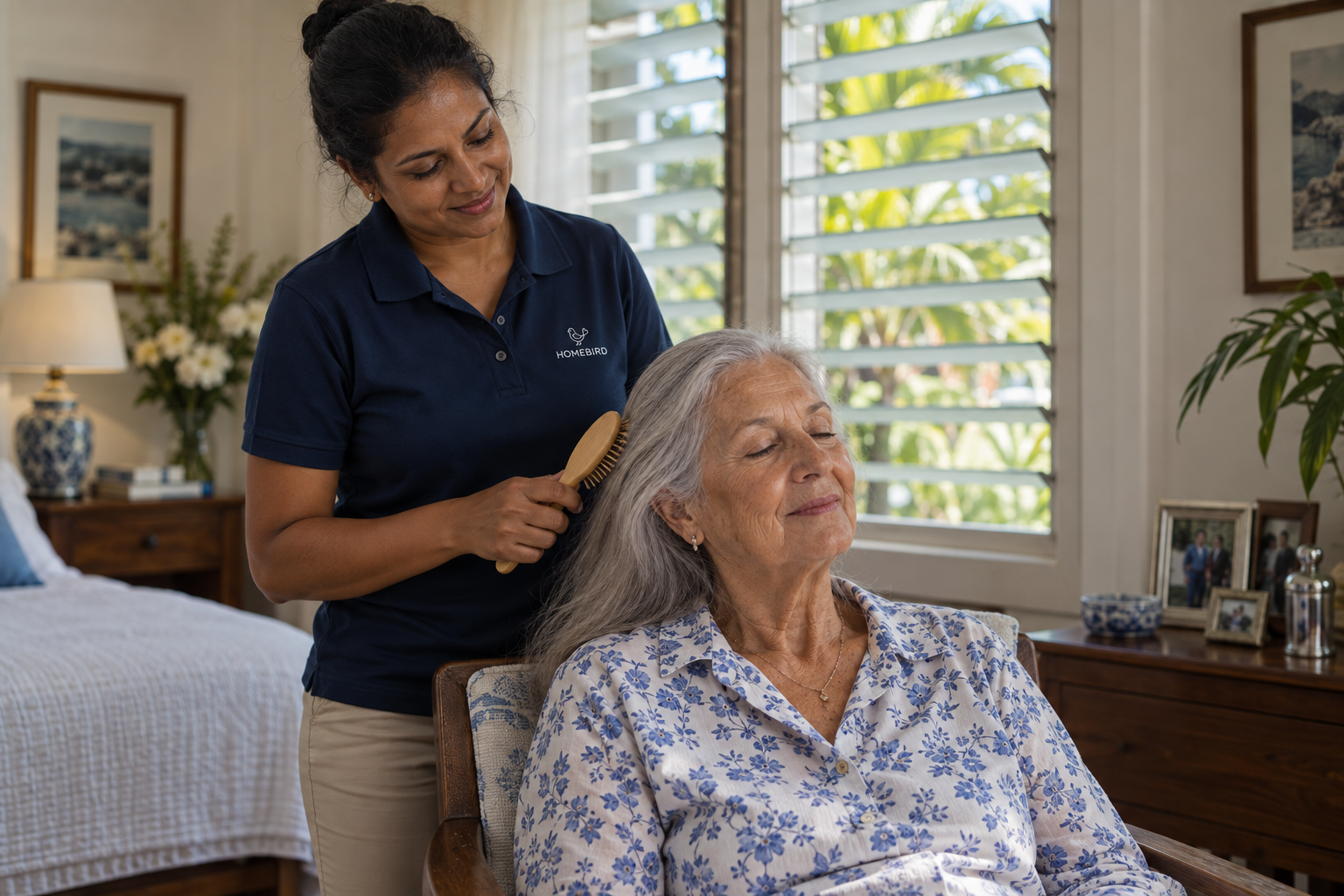 A carer gently brushing an elderly woman's hair in her own home in northern Mauritius