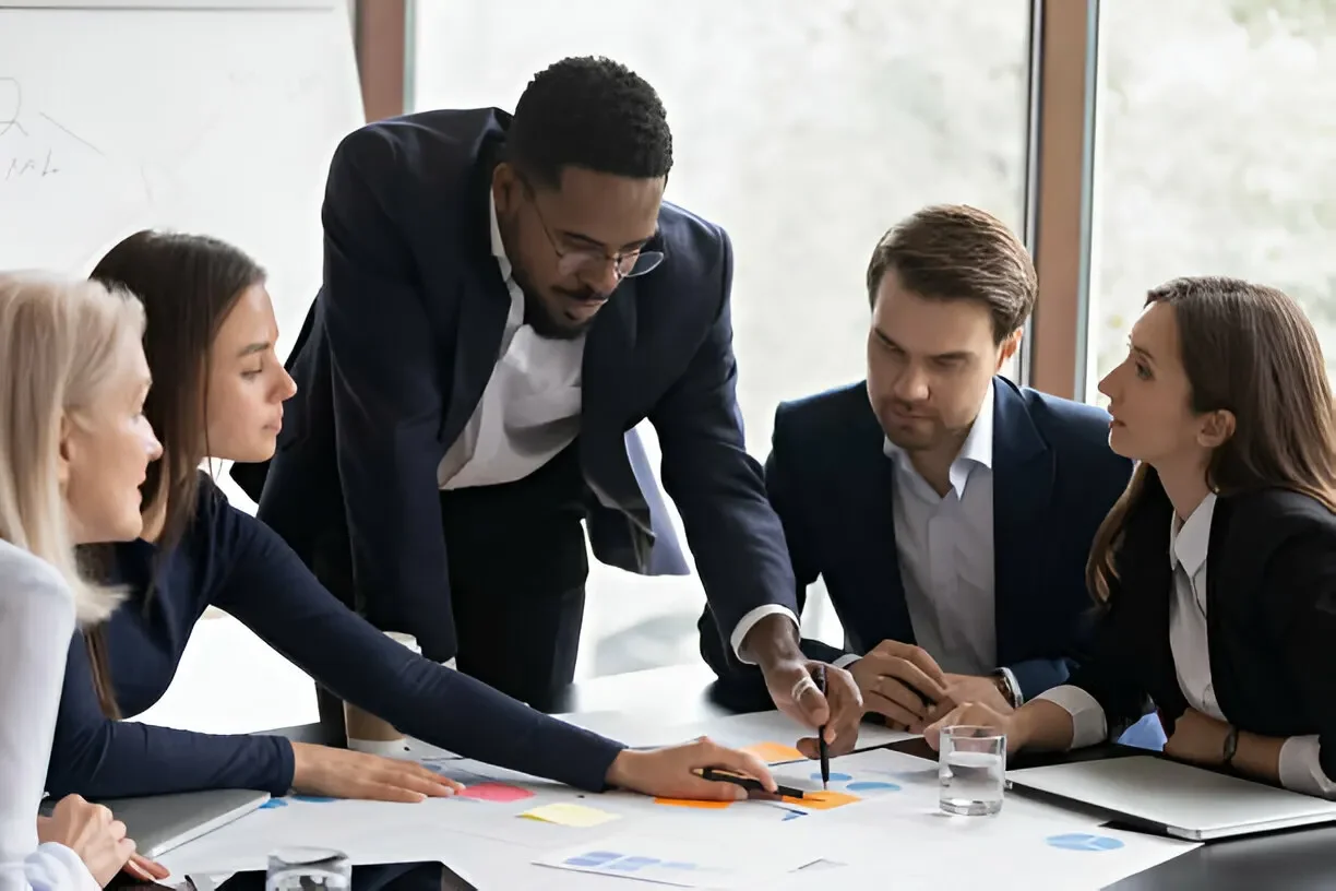 Business team in a meeting discussing charts and documents at a table.