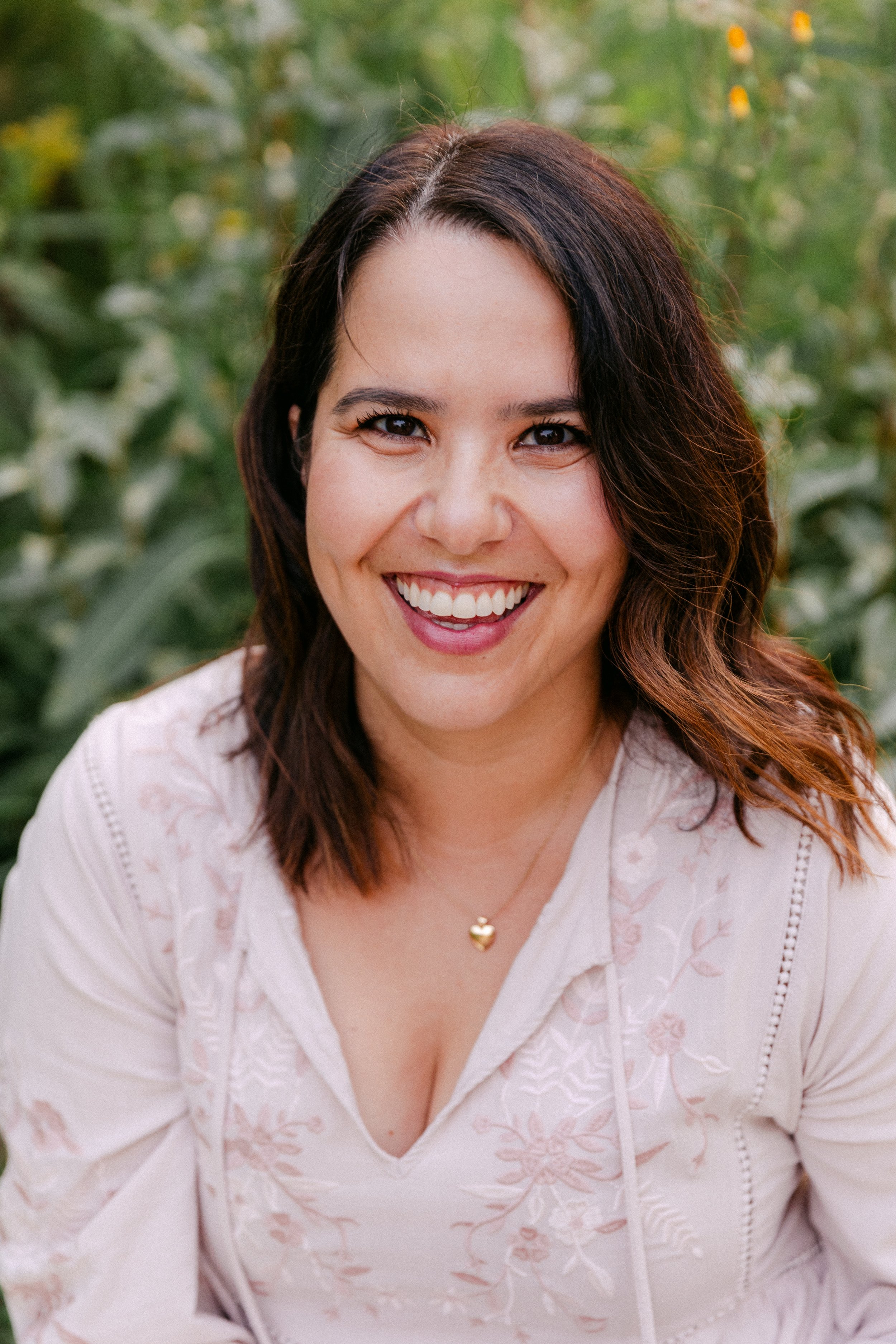 Julie Sleilaty smiles in front of greenery