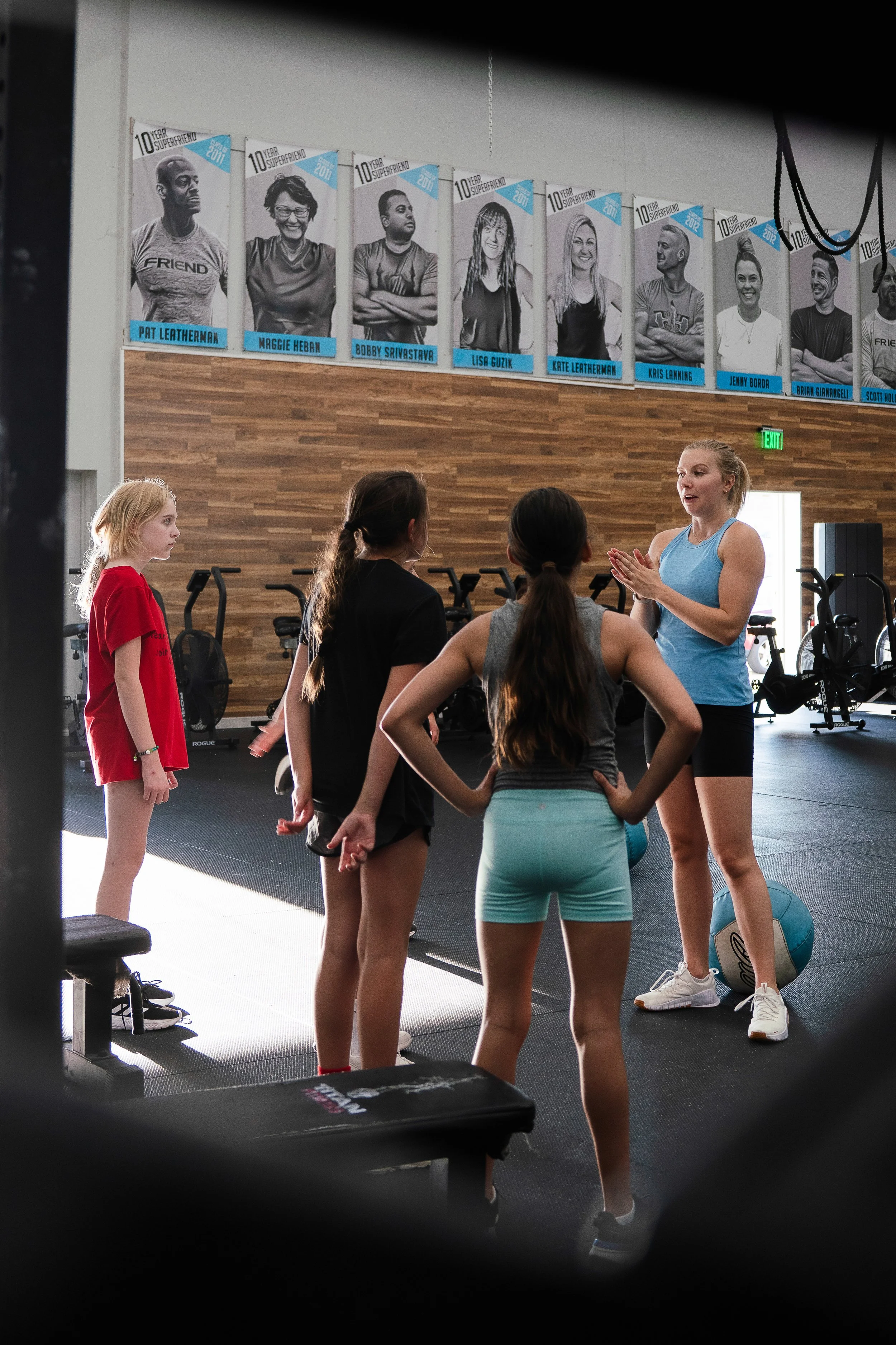 Kids inside a gym standing and listening to their coach.
