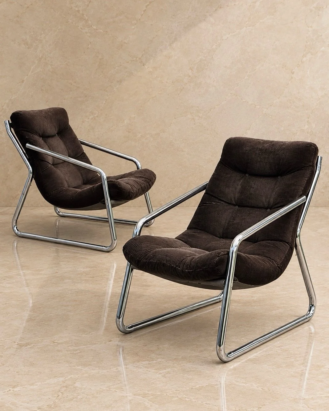 Spectacular pair of vintage lounge chairs with generous, deeply cushioned seats and sculptural tubular frames. The rich chocolate-brown upholstery has a subtle corded texture, beautifully complemented by the polished chrome. Comfortable, inviting and