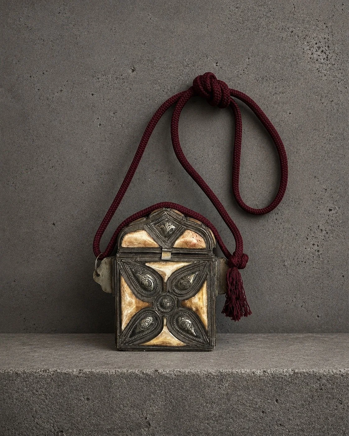 Traditional Moroccan Qur'an amulet holder with decorative horn inlay and woven cord. Such boxes were designed to hold a miniature Qur'an or sacred verses and were worn as protective talismans, combining religious devotion with a belief in spiritual p