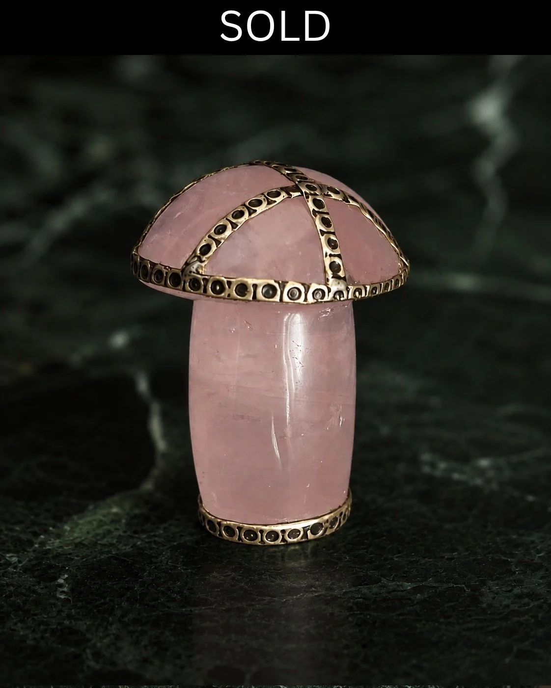 Carved form in rose quartz, its softly translucent pink stone complemented by a finely worked silver-toned finish. The absence of any visible join suggests that the piece was carved from a single block of stone, while the intricate dotted detailing l