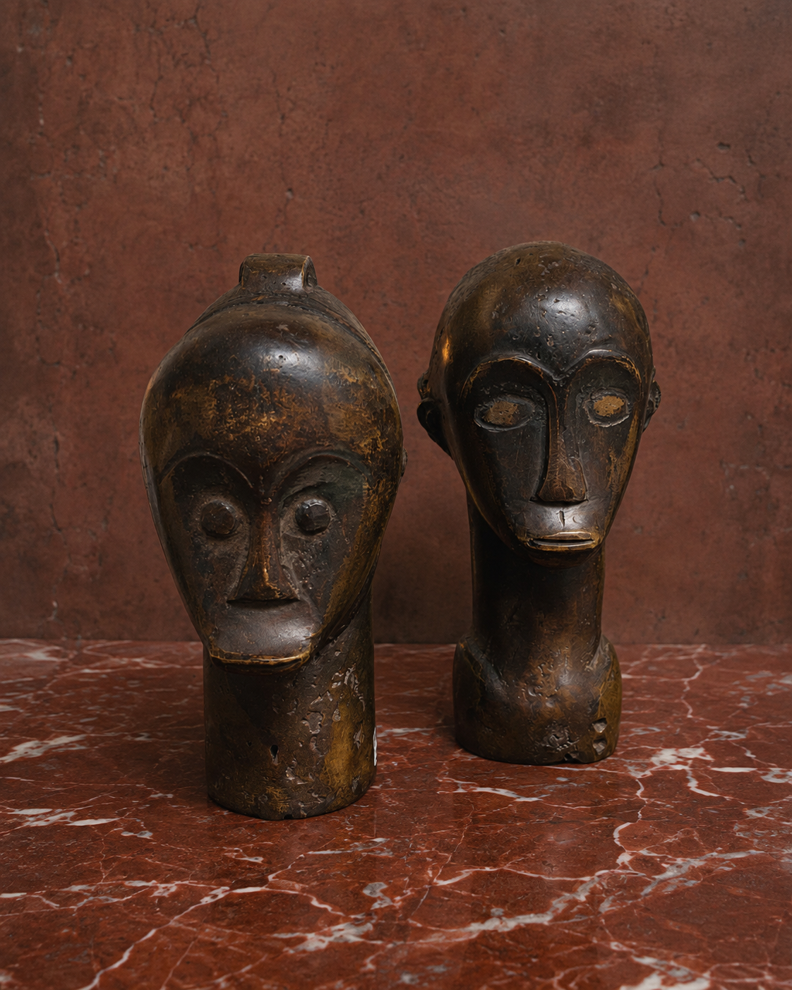 Compelling pair of bronze busts depicting a male and female figure, from Gabon and believed to be associated with the Fang tradition. Their highly stylised features and richly aged patina give both sculptures a powerful and timeless presence. Present