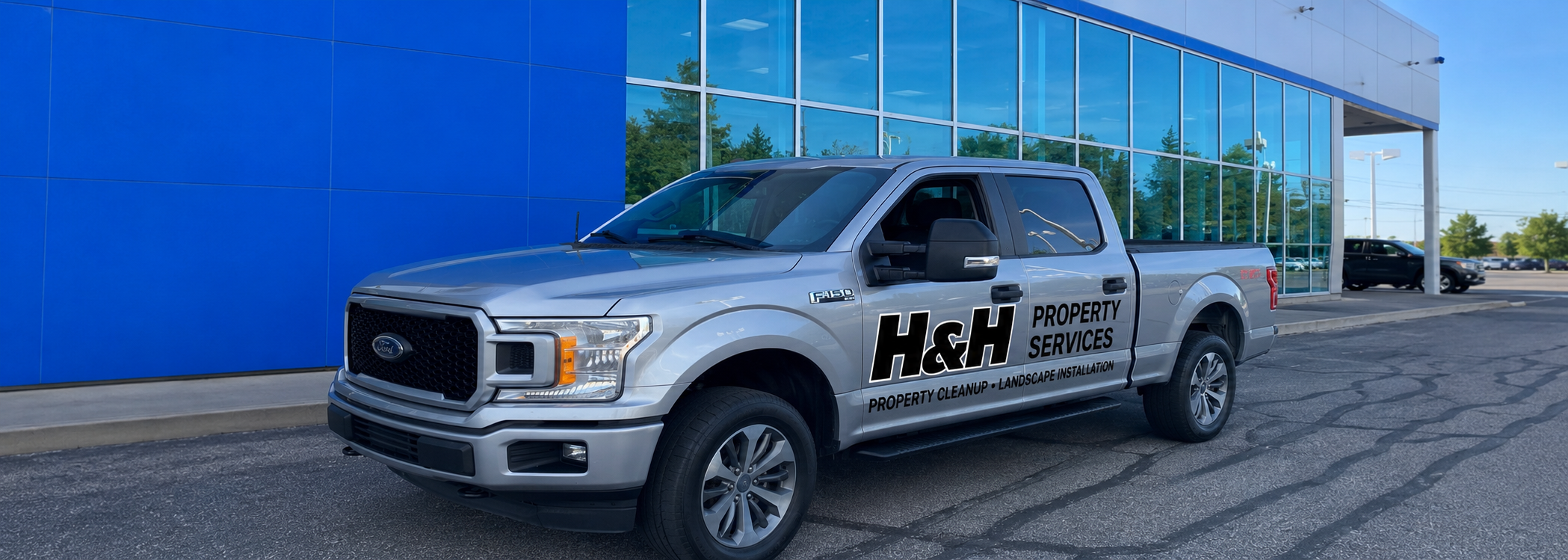 H&H Property Services truck parked in front of a professionally landscaped home with fresh mulch, edging, and landscape installation in Greater Cleveland, Ohio.