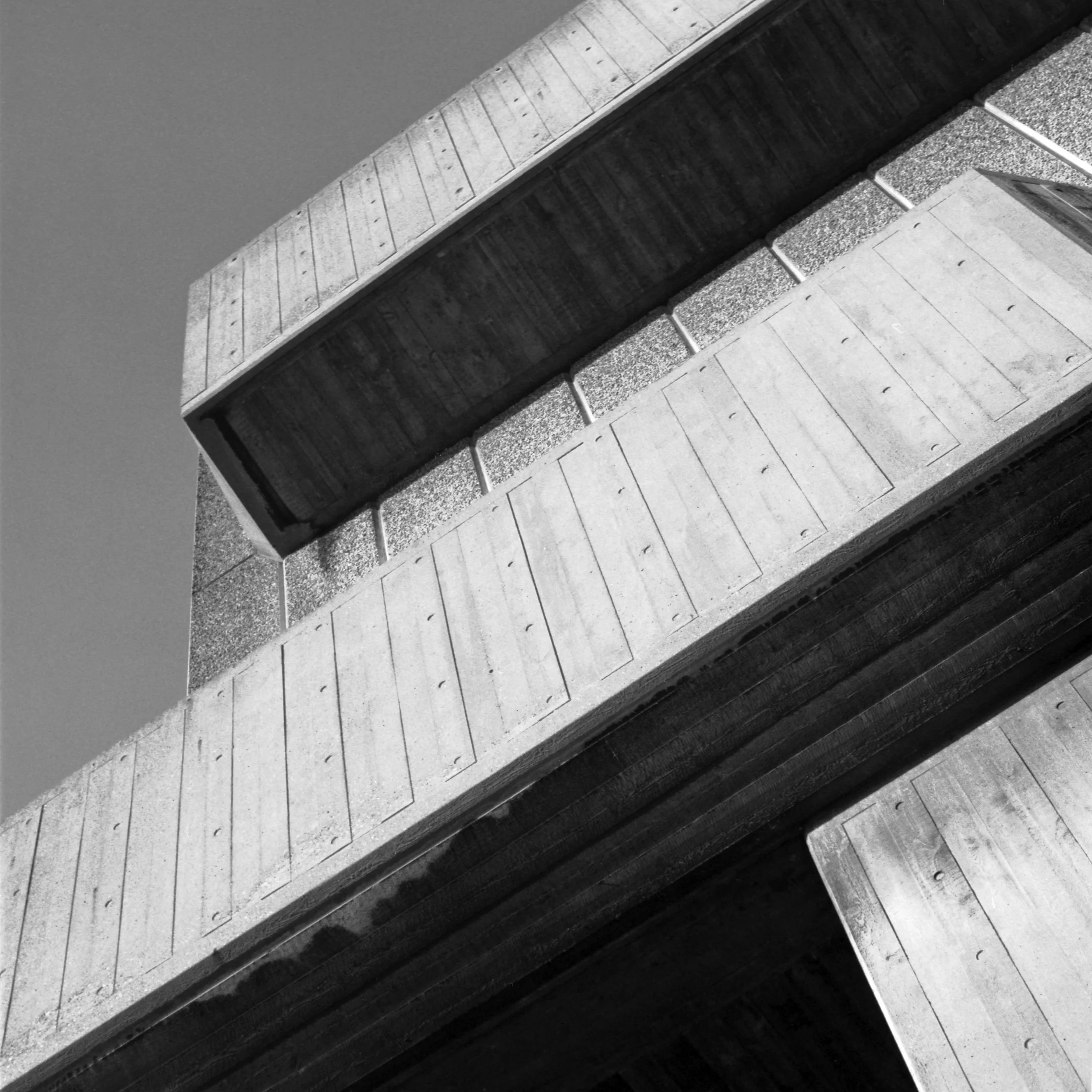 Close-up of architectural detail showing different textured rectangular tiles arranged in horizontal and vertical patterns on a building facade at the at Southbank Centre in London, United Kingdom. Black and white architecture photograph.