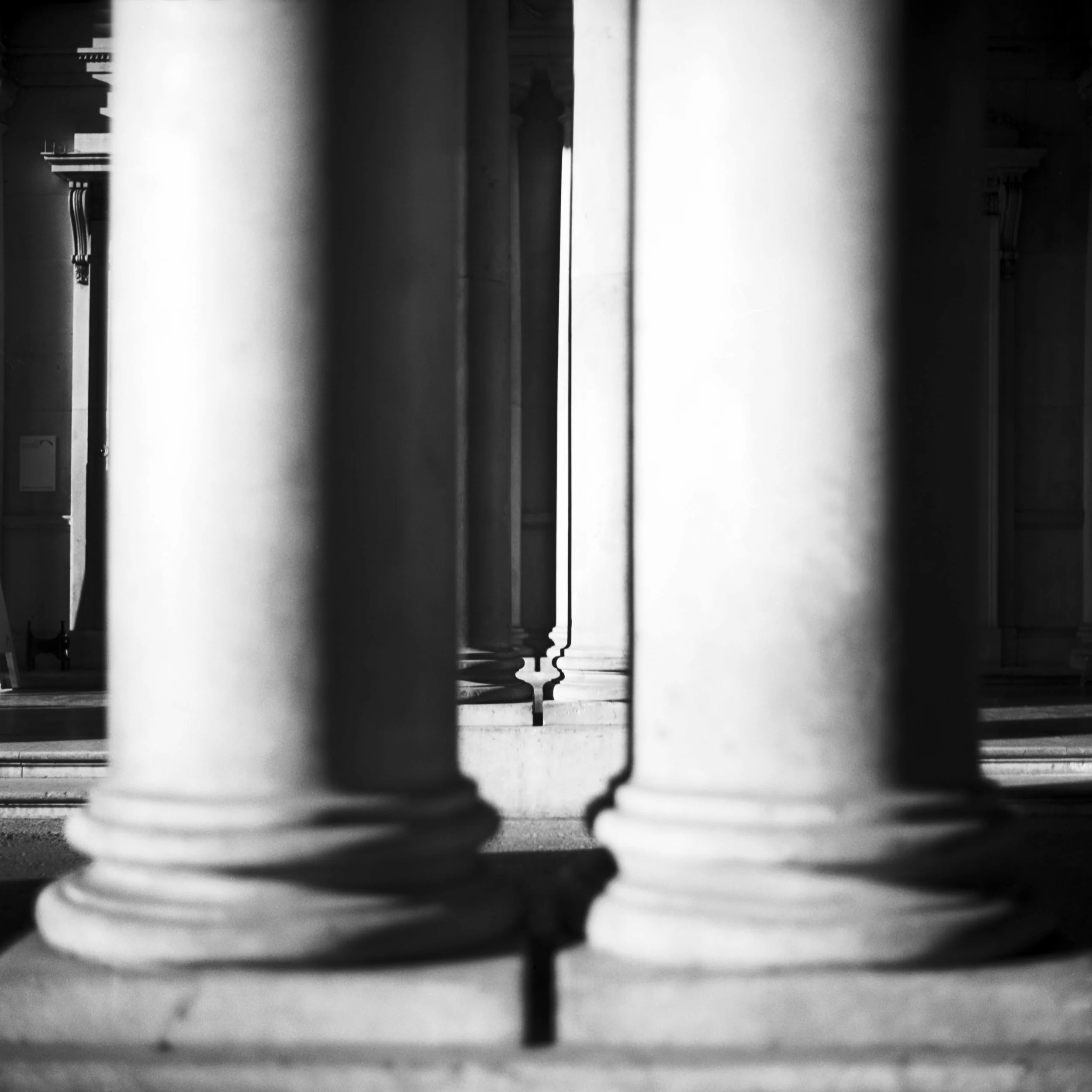 Close-up of building columns in London, United Kingdom. Black and white architecture photograph.