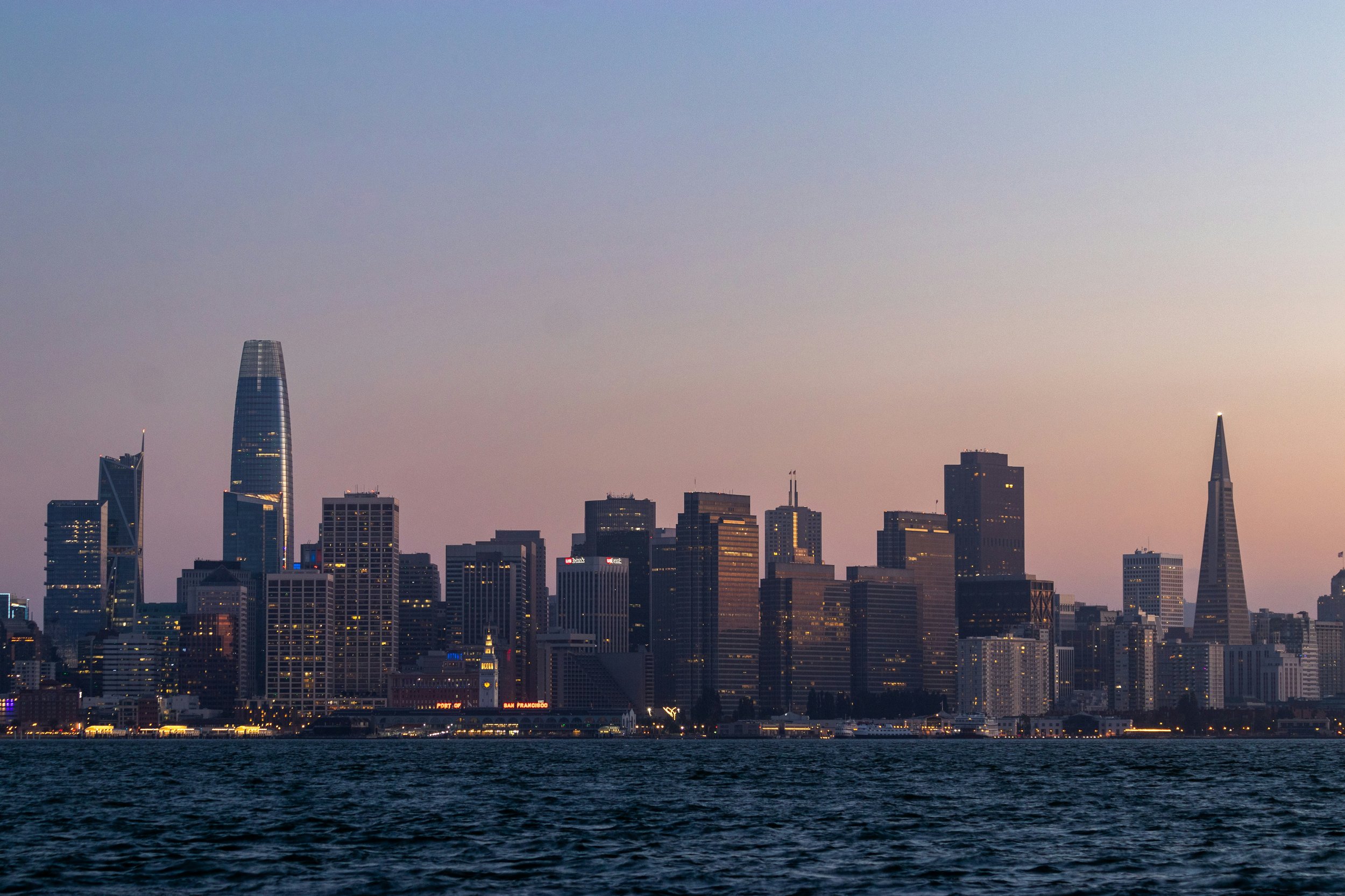San Francisco skyline viewed across the bay at dusk from a ferry.
