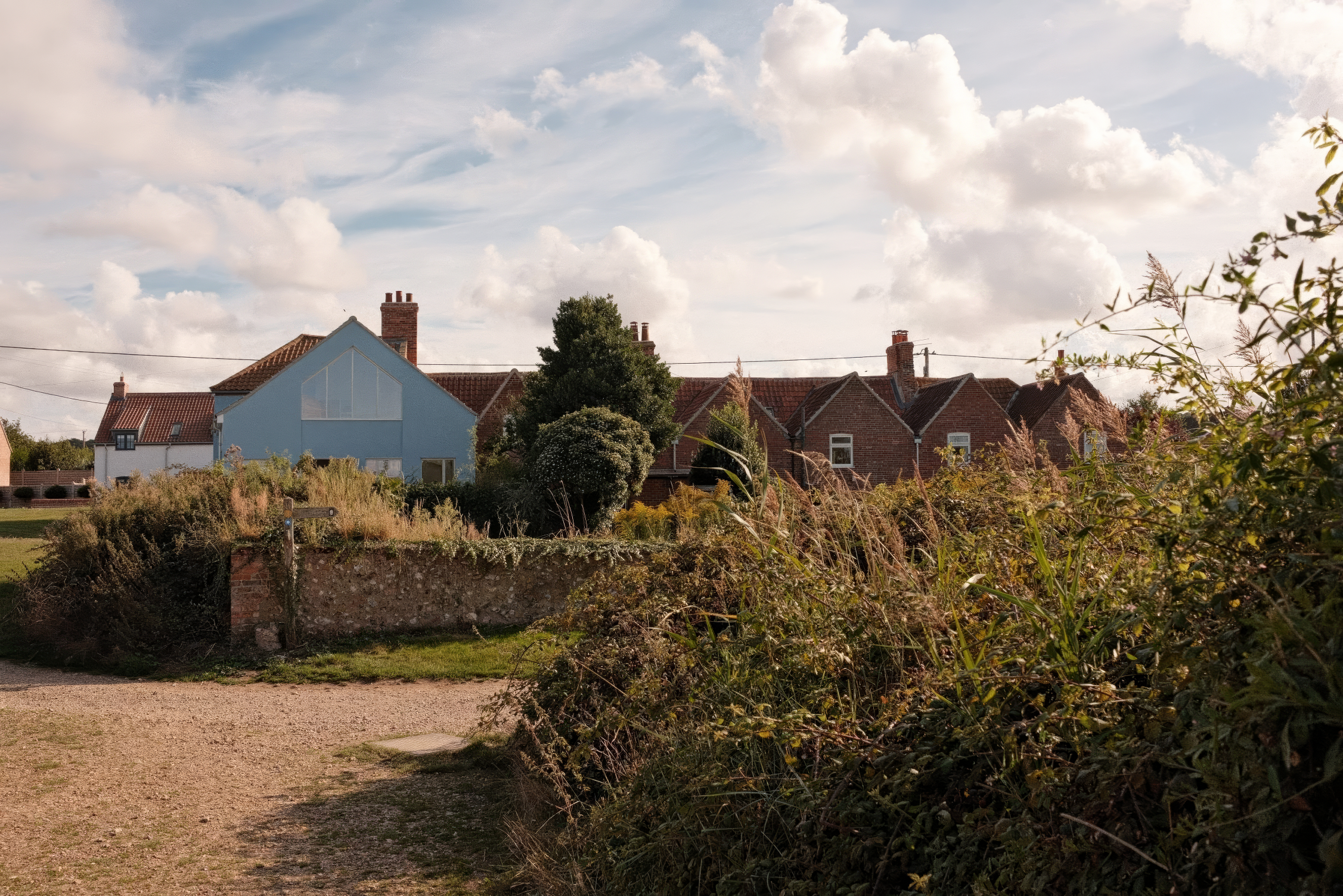 Coastal village scene featuring a sky-blue modern house.