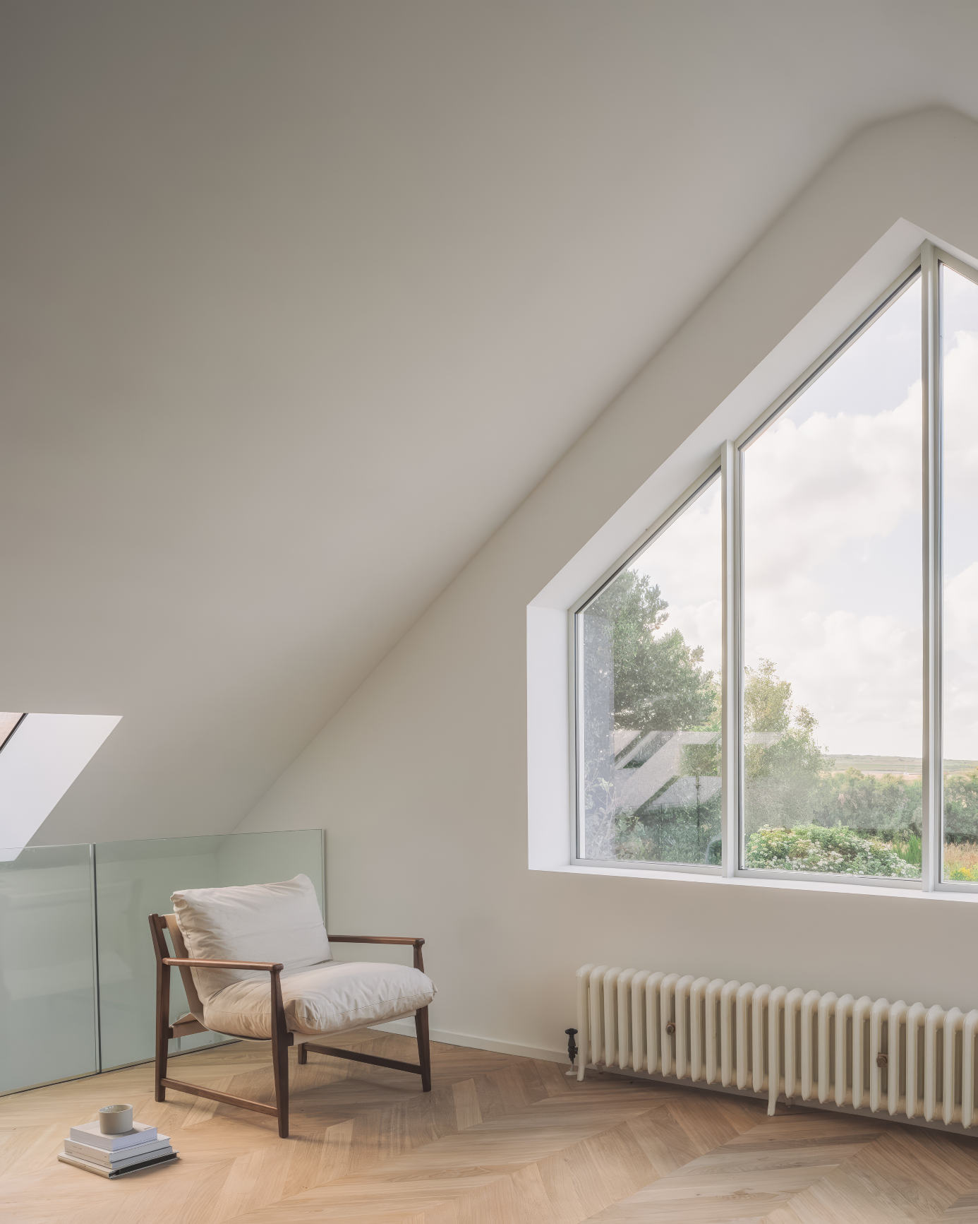 Minimalist corner with cushioned armchair by a large geometric window.