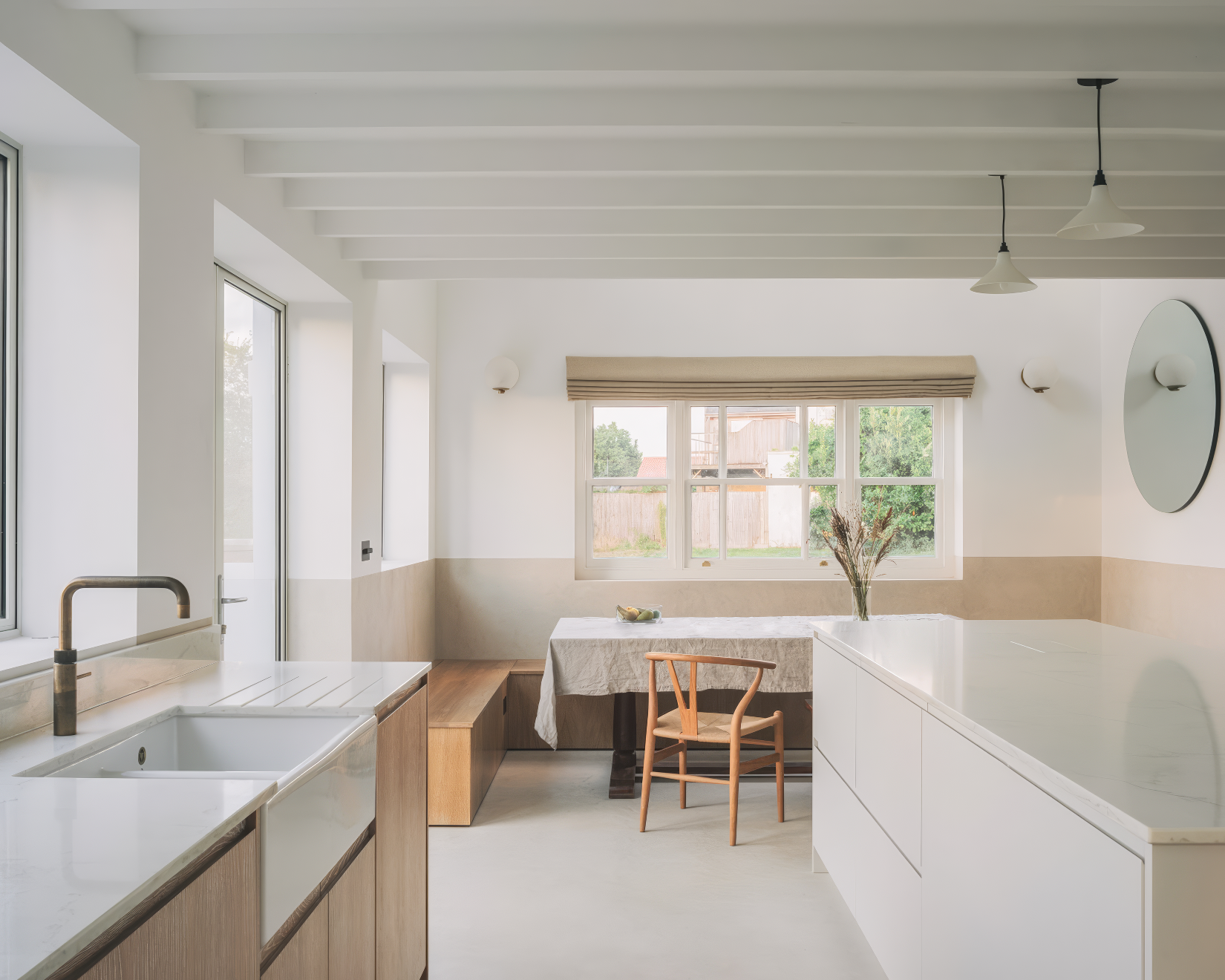 Airy kitchen-dining space with white beams and built-in banquette.
