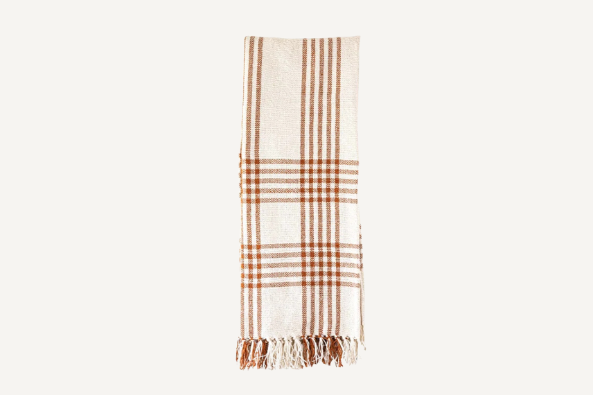 Handmade indoor outdoor throw in tonal rust colors woven into a cream background.