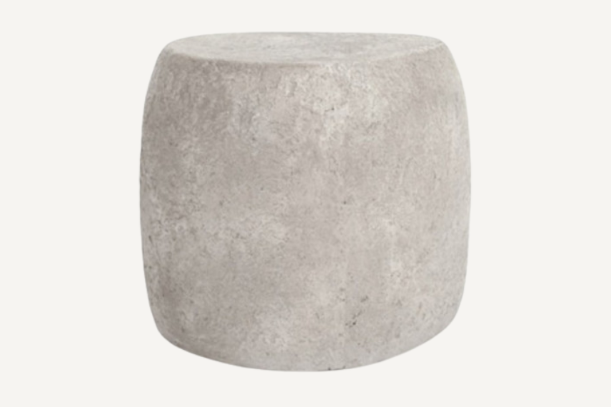 Beautiful outdoor concrete stone end table in natural stone color and imperfections set against a neutral background.