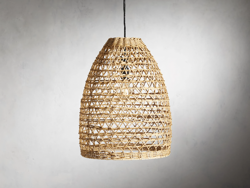 A natural wicker woven outdoor light pendant hanging from the ceiling with a grey background.