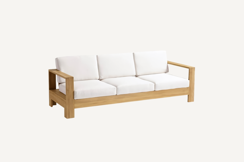 Boretto Sofa in Natural Teak has wide-plank arms and comfortably angled seat back, with soft seating cushions all set on a neutral background.
