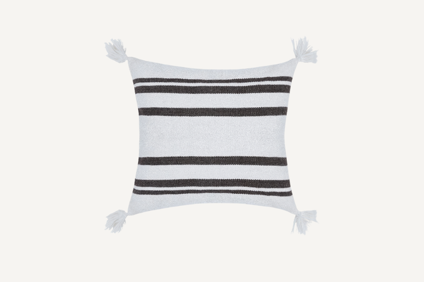 Square decorative pillow with a white base and bold black horizontal stripes, featuring tassels at each corner. The design blends modern and classic elements, making it a stylish accent piece for indoor or outdoor spaces.