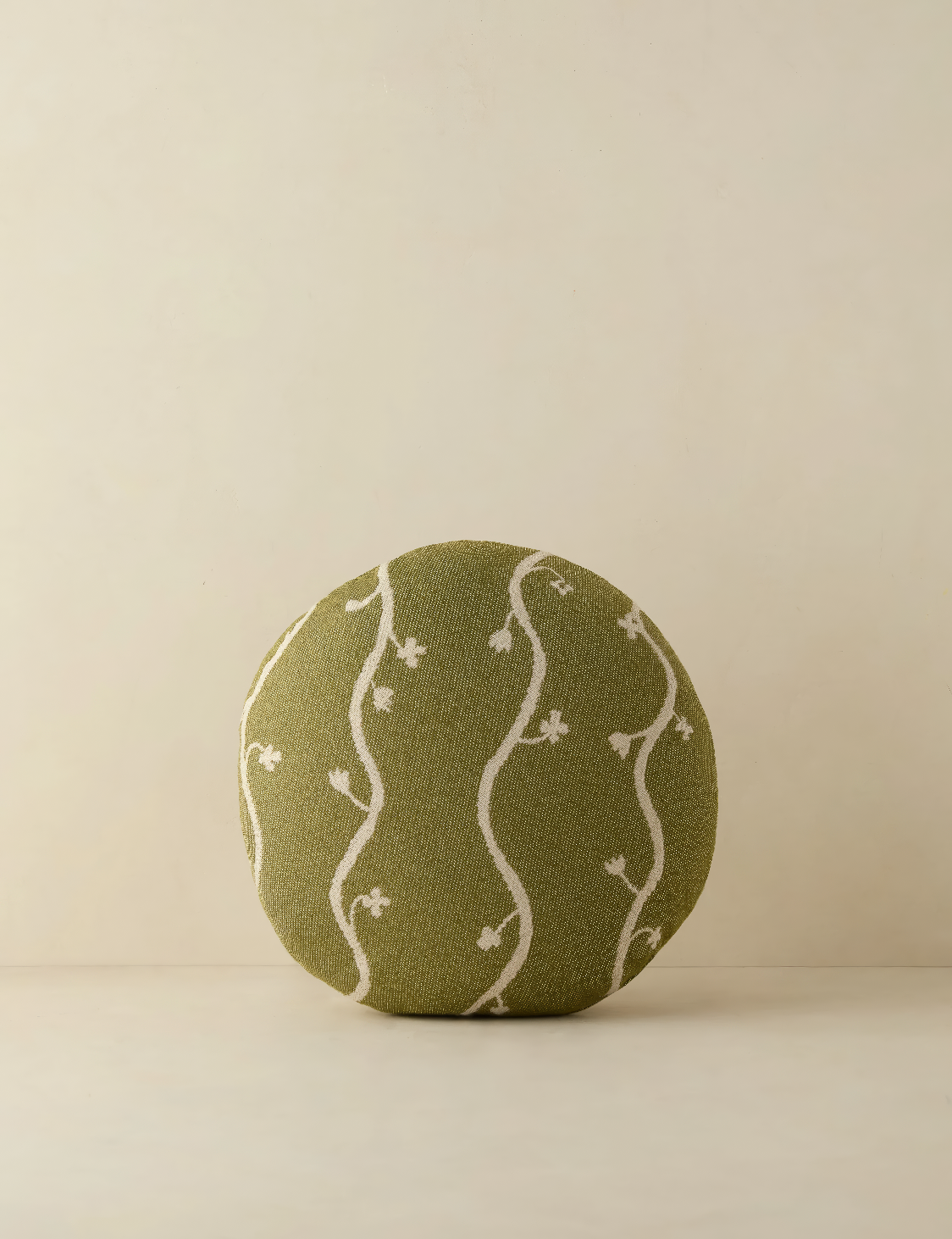 Round olive-green pillow with a delicate white vine pattern, featuring wavy, embroidered lines and small floral details. The soft, organic design adds a touch of nature-inspired charm, perfect for indoor or outdoor spaces.