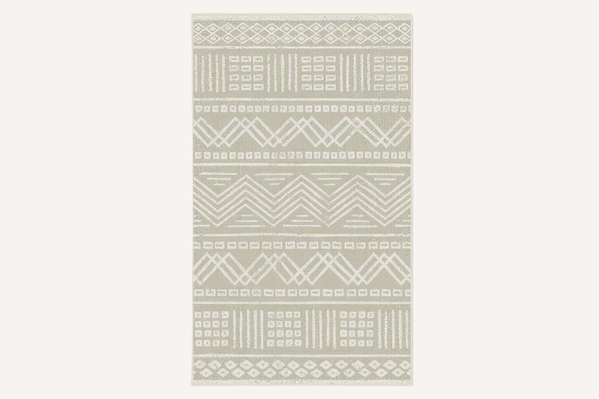 Rectangular outdoor rug featuring a natural beige and white tribal-inspired geometric pattern. The intricate design includes zigzags, diamonds, and linear motifs, adding a subtle yet stylish touch to any outdoor or indoor space.