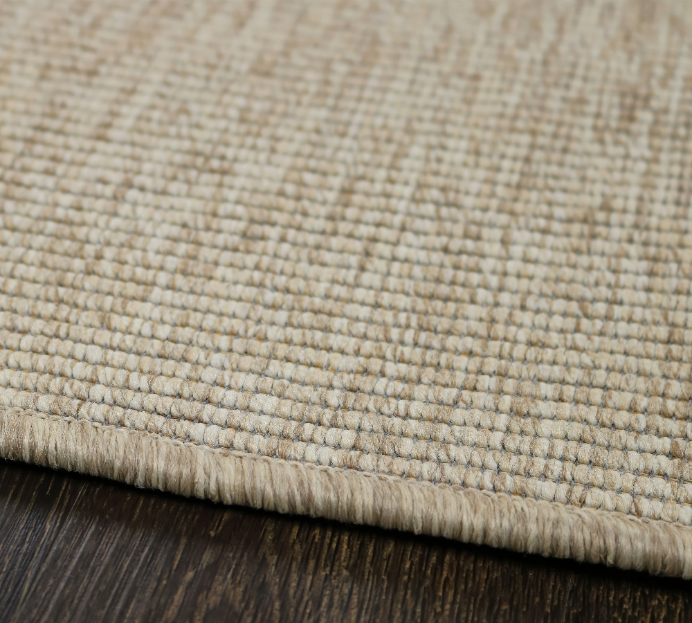 Rectangular outdoor rug with a tightly woven boucle texture in a warm, natural tan color. The simple, durable design adds a subtle, organic touch to patios, decks, or indoor spaces.