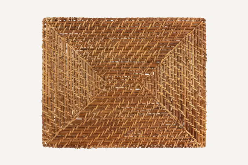Rectangular woven rattan placemat featuring a detailed diagonal weave pattern in warm, natural brown tones. The handcrafted texture adds a rustic yet sophisticated touch to any table setting.